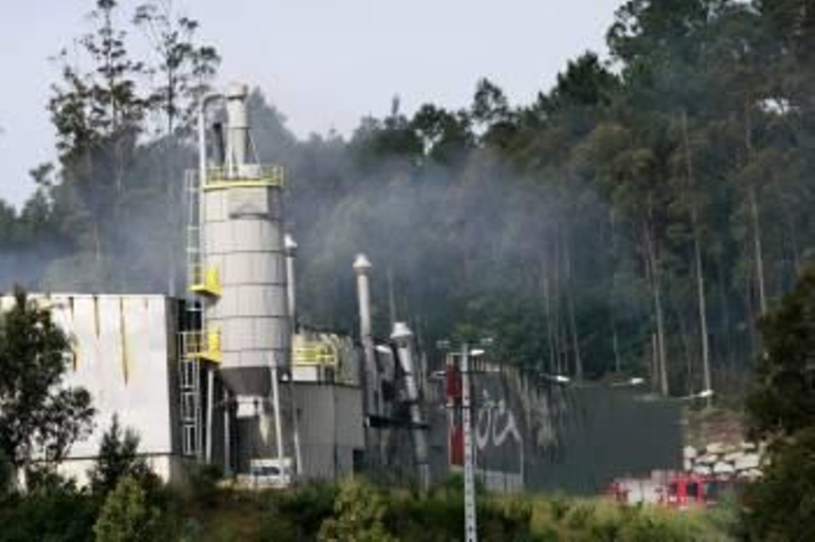 Un camión de bomberos permanece en el exterior del recinto donde un incendio calcinó esta madrugada una nave que almacenaba madera, en el polígono industrial de Vilar do Colo (Foto: Kiko)