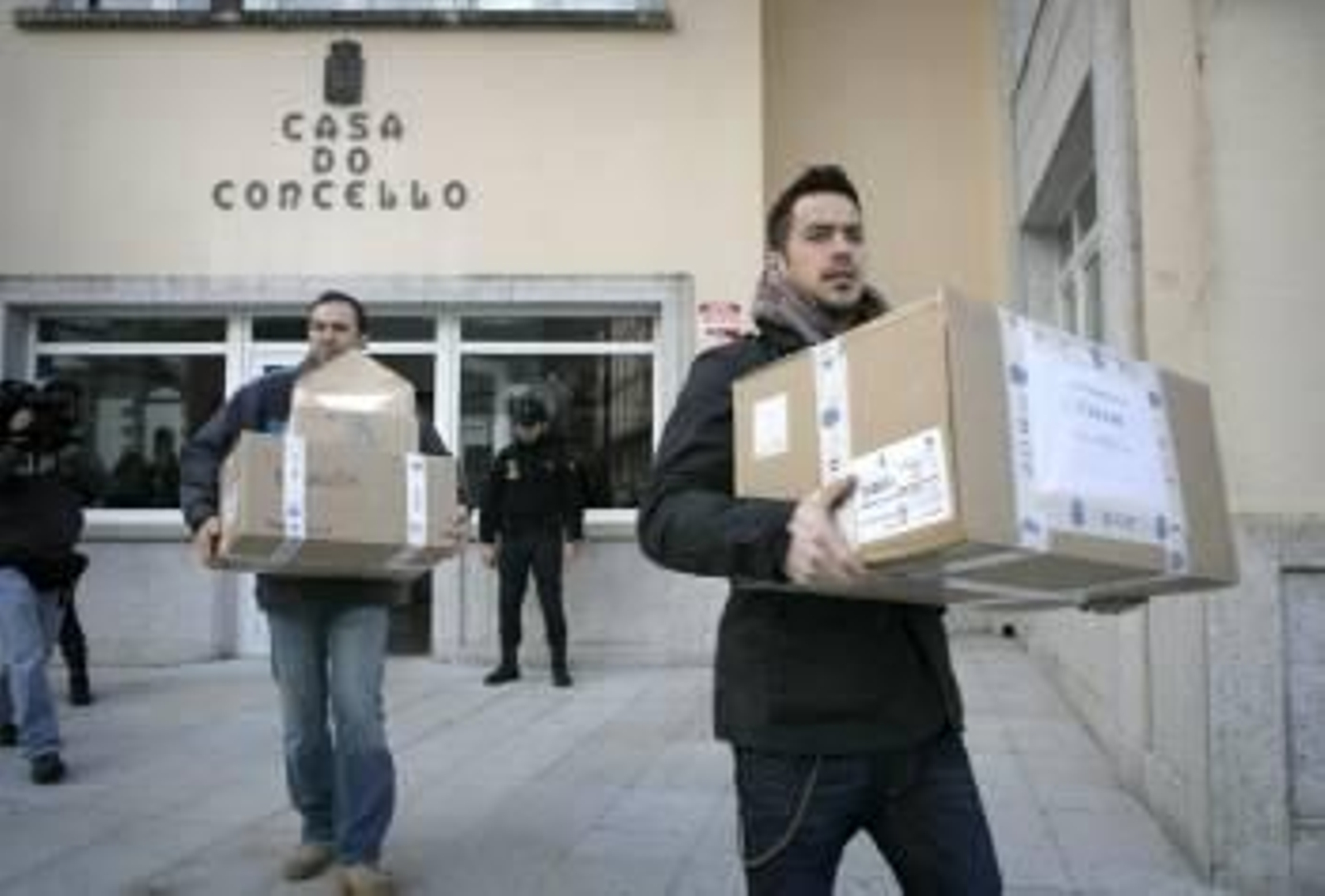 Agentes de la Policía portan documentación intervenida en el registro de la consistorial de Cee. (Foto: CABALAR)