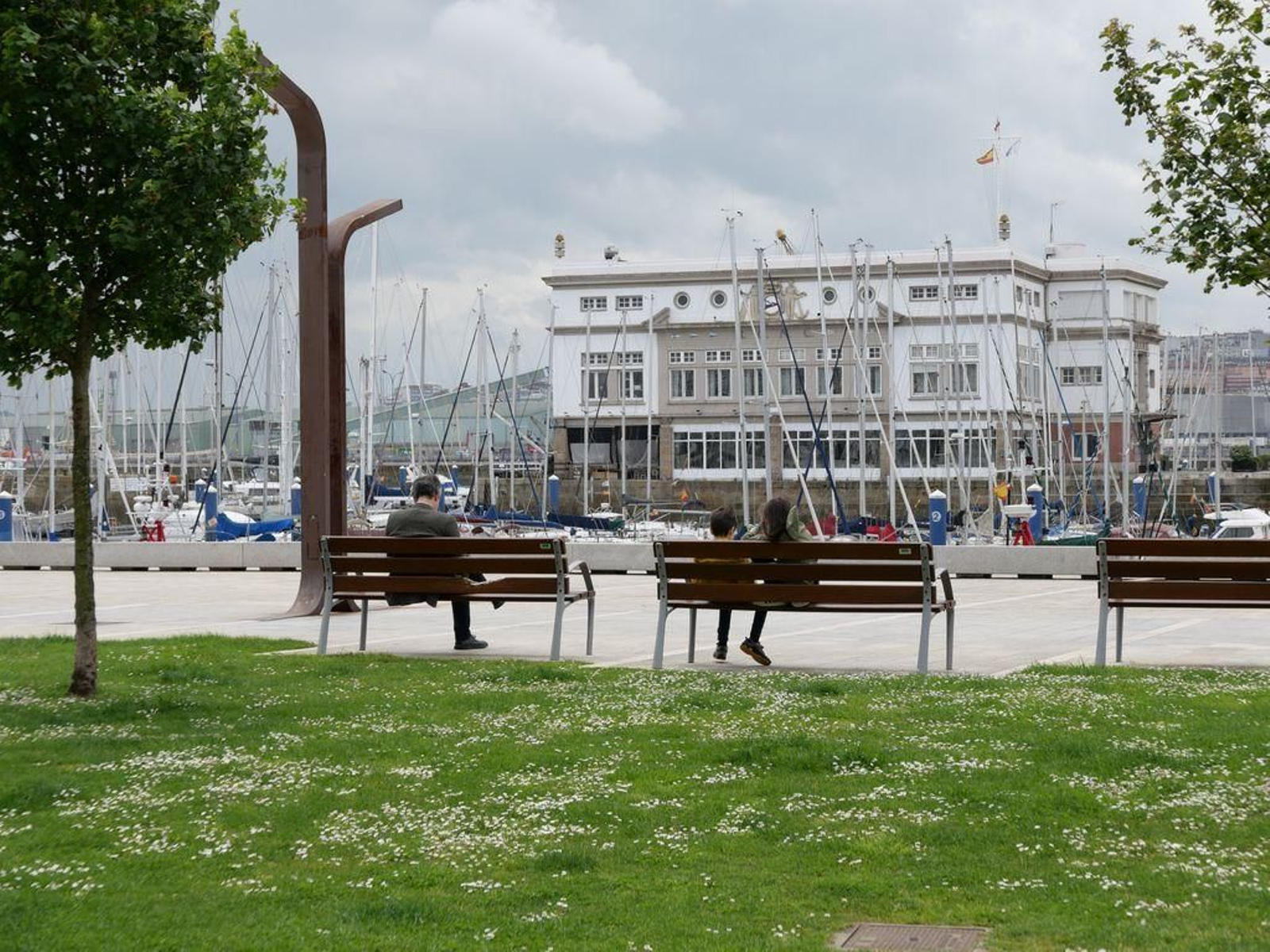 Niños sentados en un banco de La Marina de A Coruña