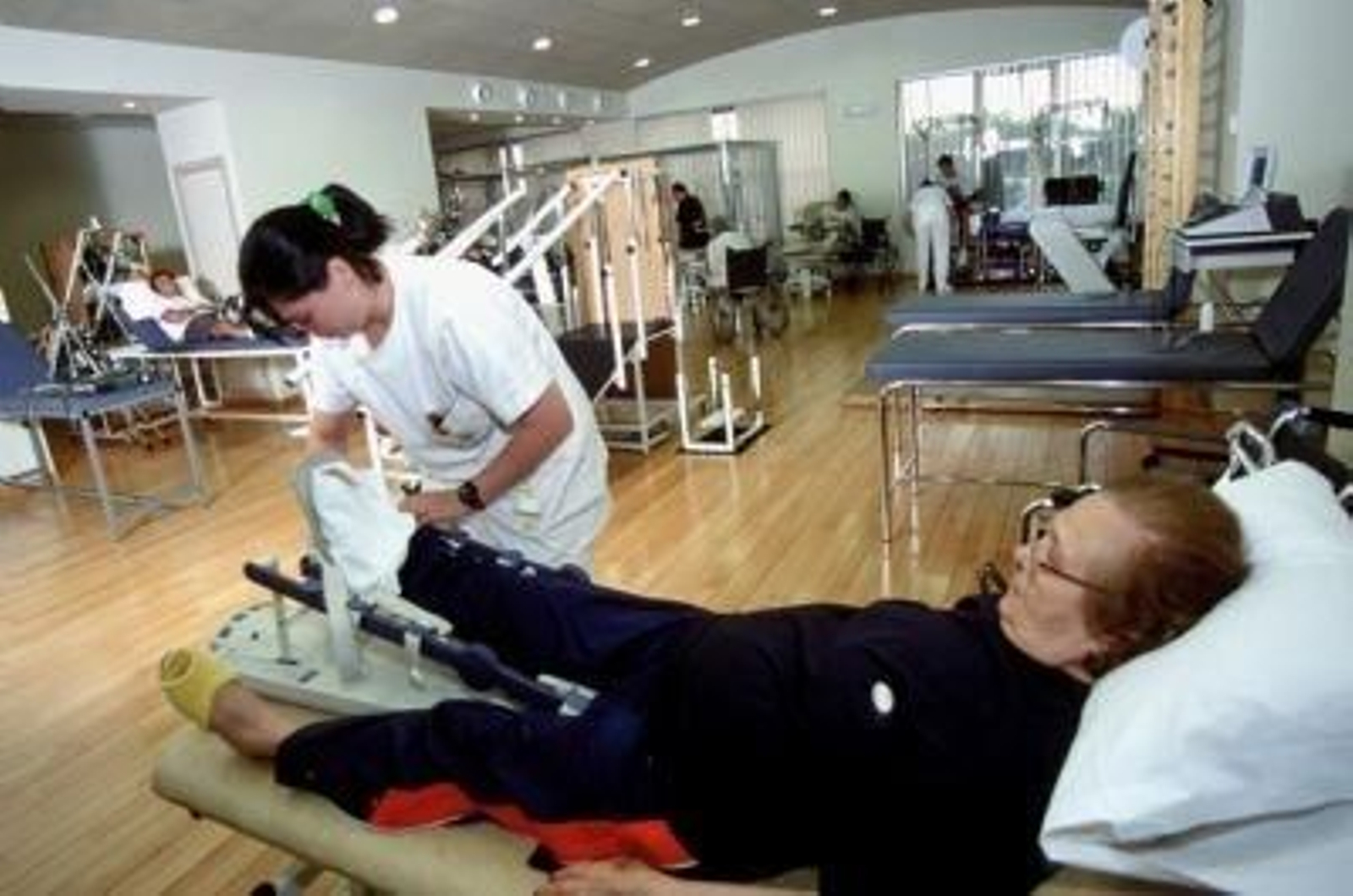 Una fisioterapeuta atiende a una paciente.