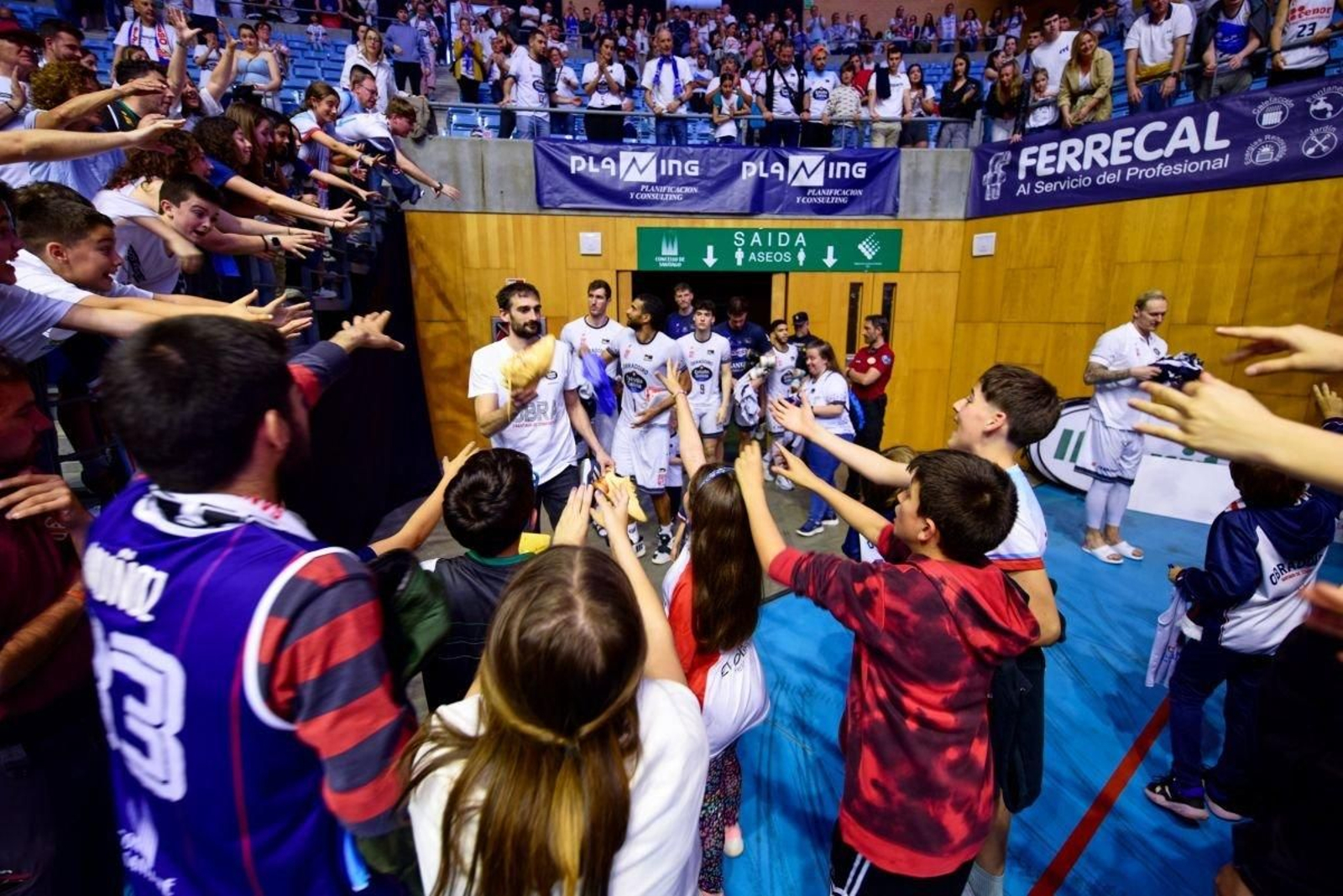 Aficionados del Obradoiro saludan a los jugadores tras el descenso.