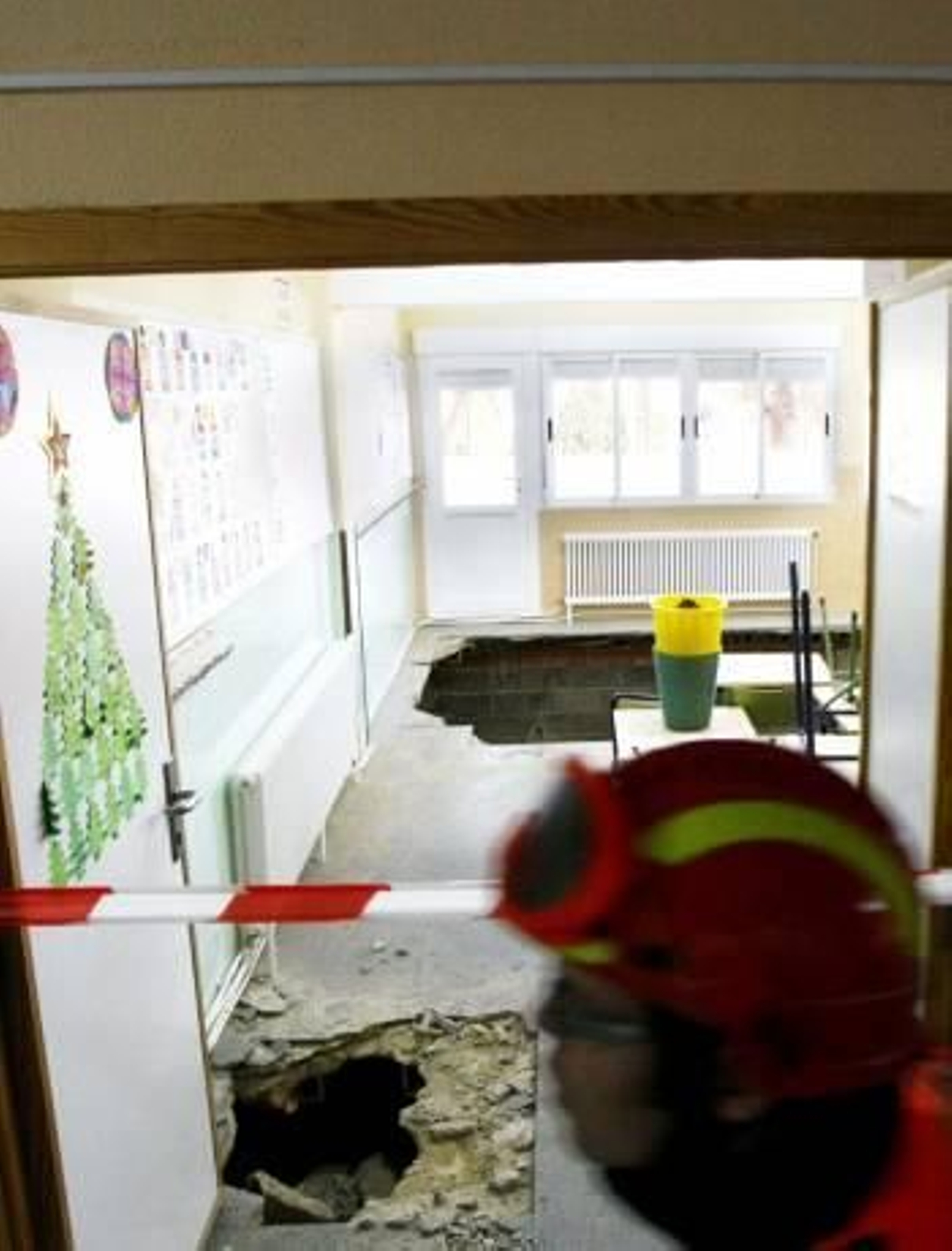 Un bombero pasa ante el socavón en el suelo del aula. (Foto: MORELL)