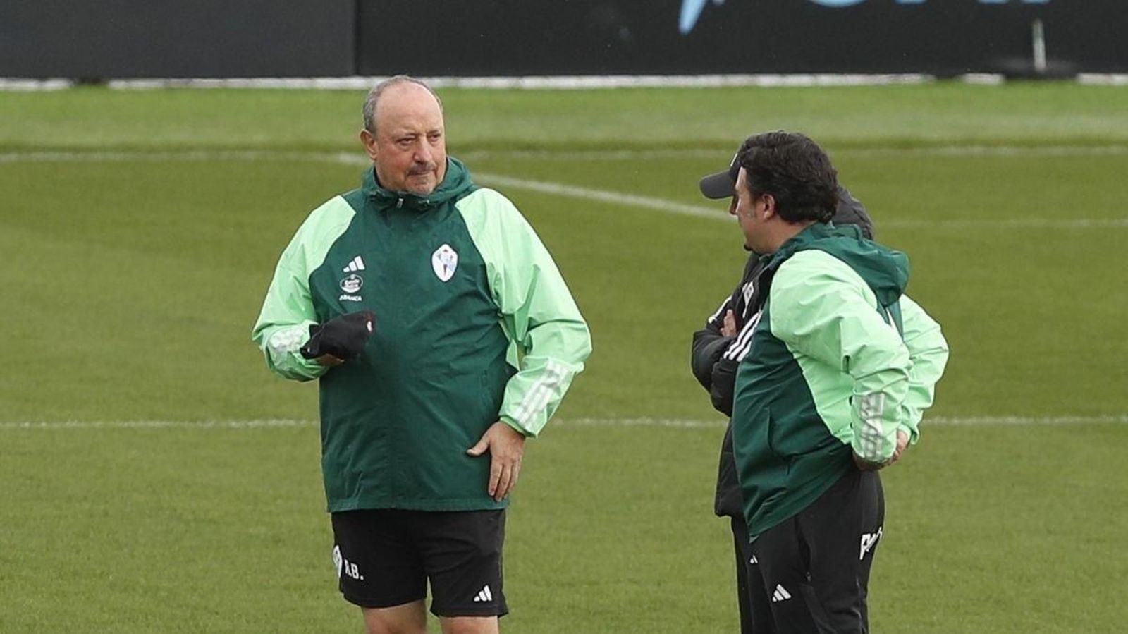 Rafa Benítez habla con su cuerpo técnico durante el entrenamiento de ayer en Mos.
