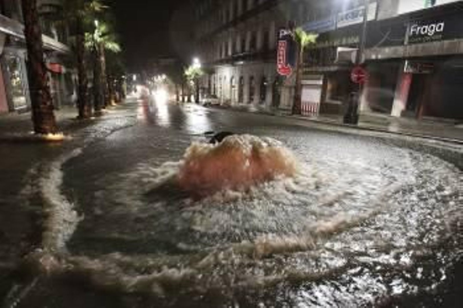 El agua sale sin control de una alcantarilla tras hacer saltar la tapa durante la tormenta en Vigo. (Foto: SXENICK)