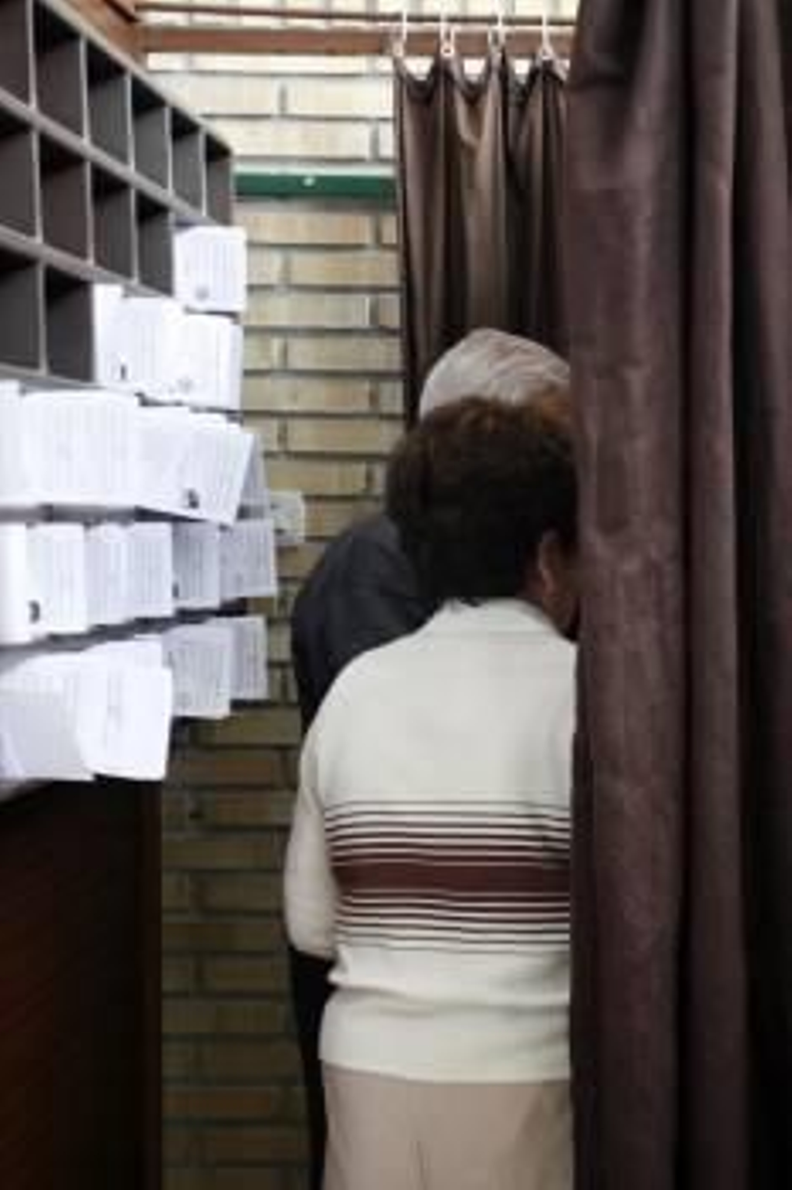 Una pareja, en el interior de una cabina en un colegio electoral. (Foto: ARCHIVO)