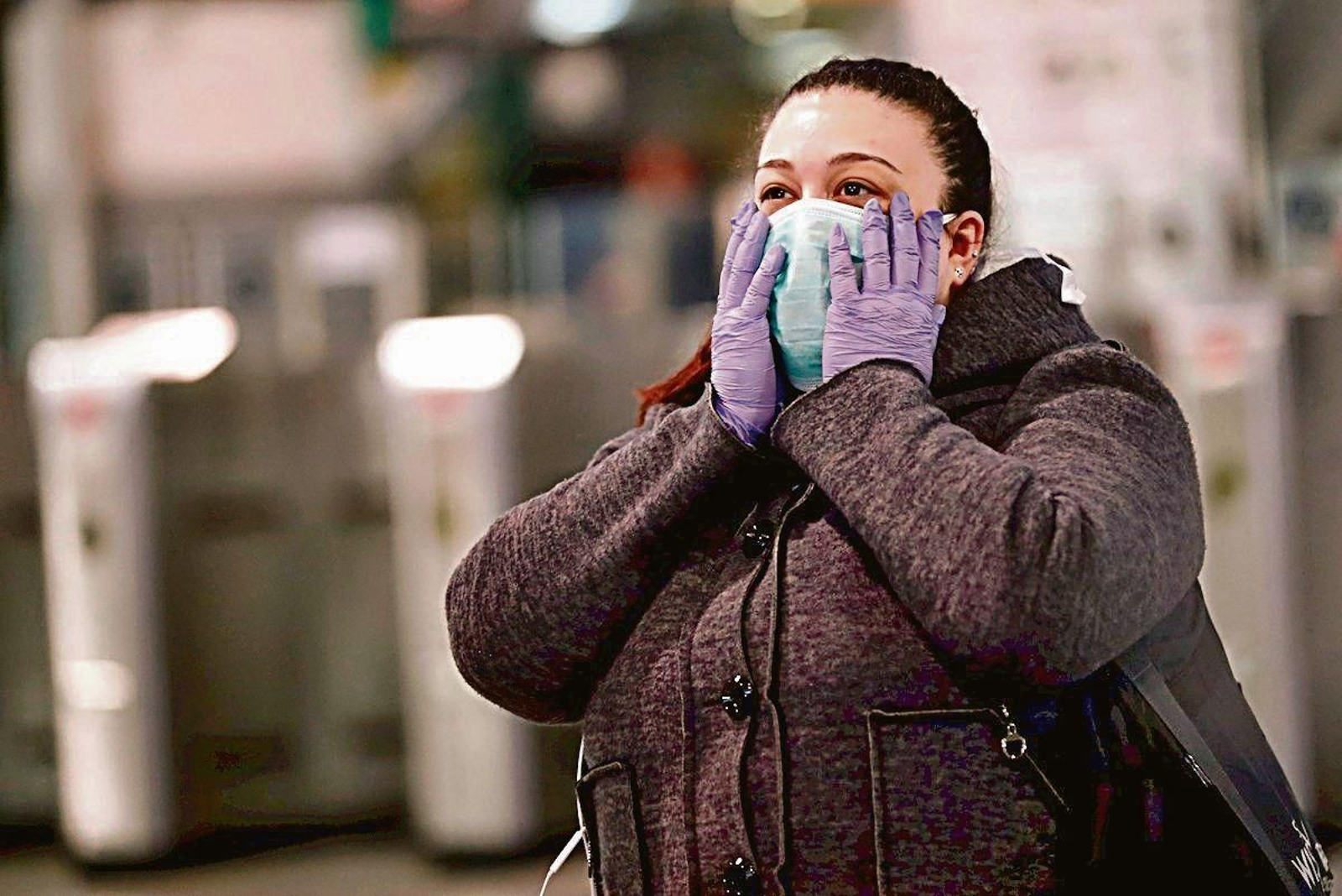 Una mujer se protege con una mascarilla sanitaria.