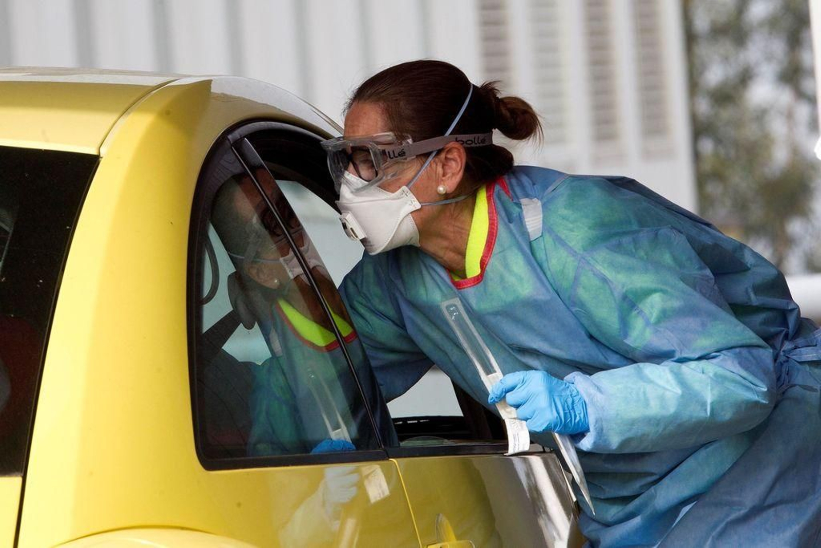 Una sanitaria del Hospital Meixoeiro de Vigo toma muestras a una persona desde el coche.