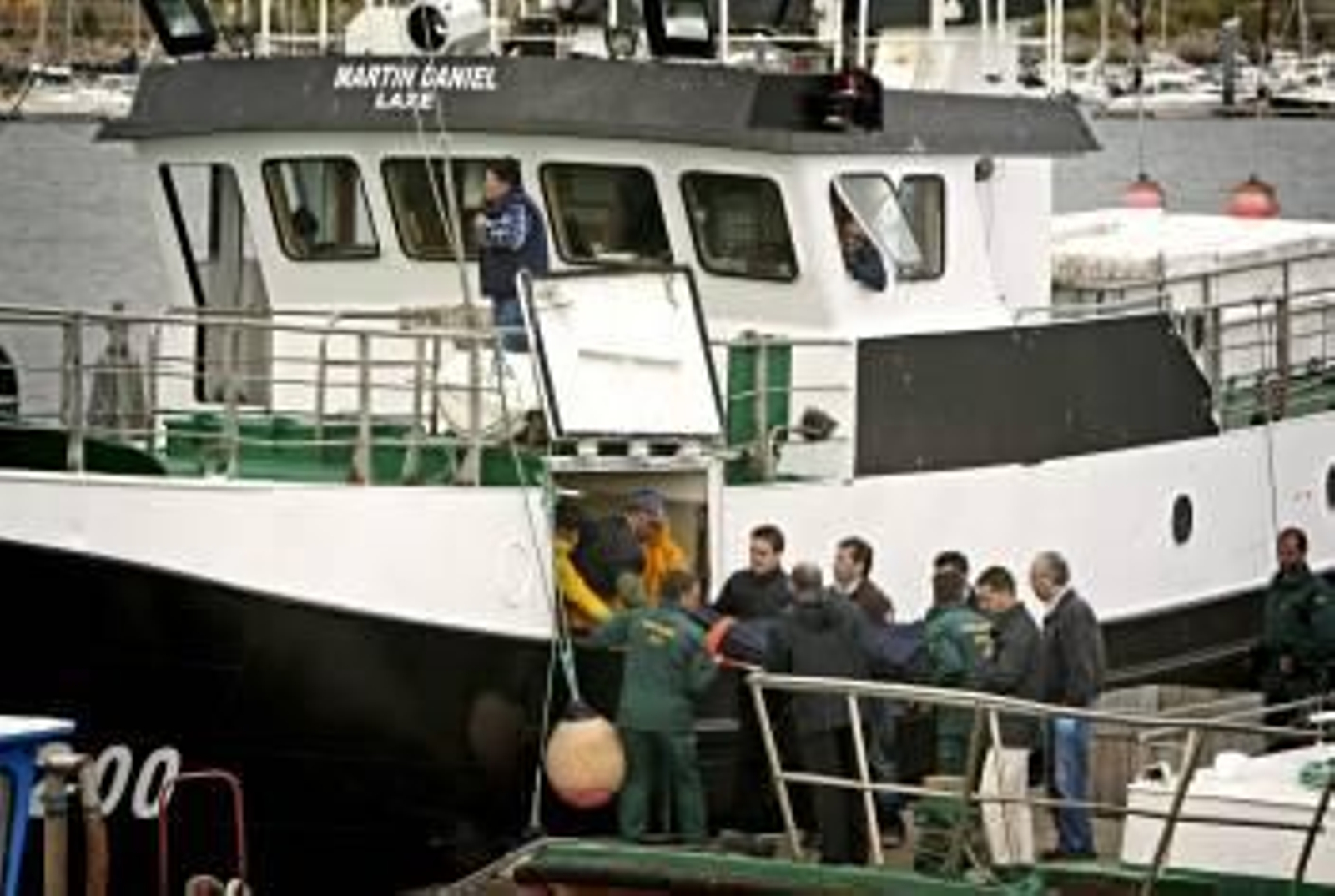 Llegada a puerto de uno de los cadáveres. (Foto: EFE)