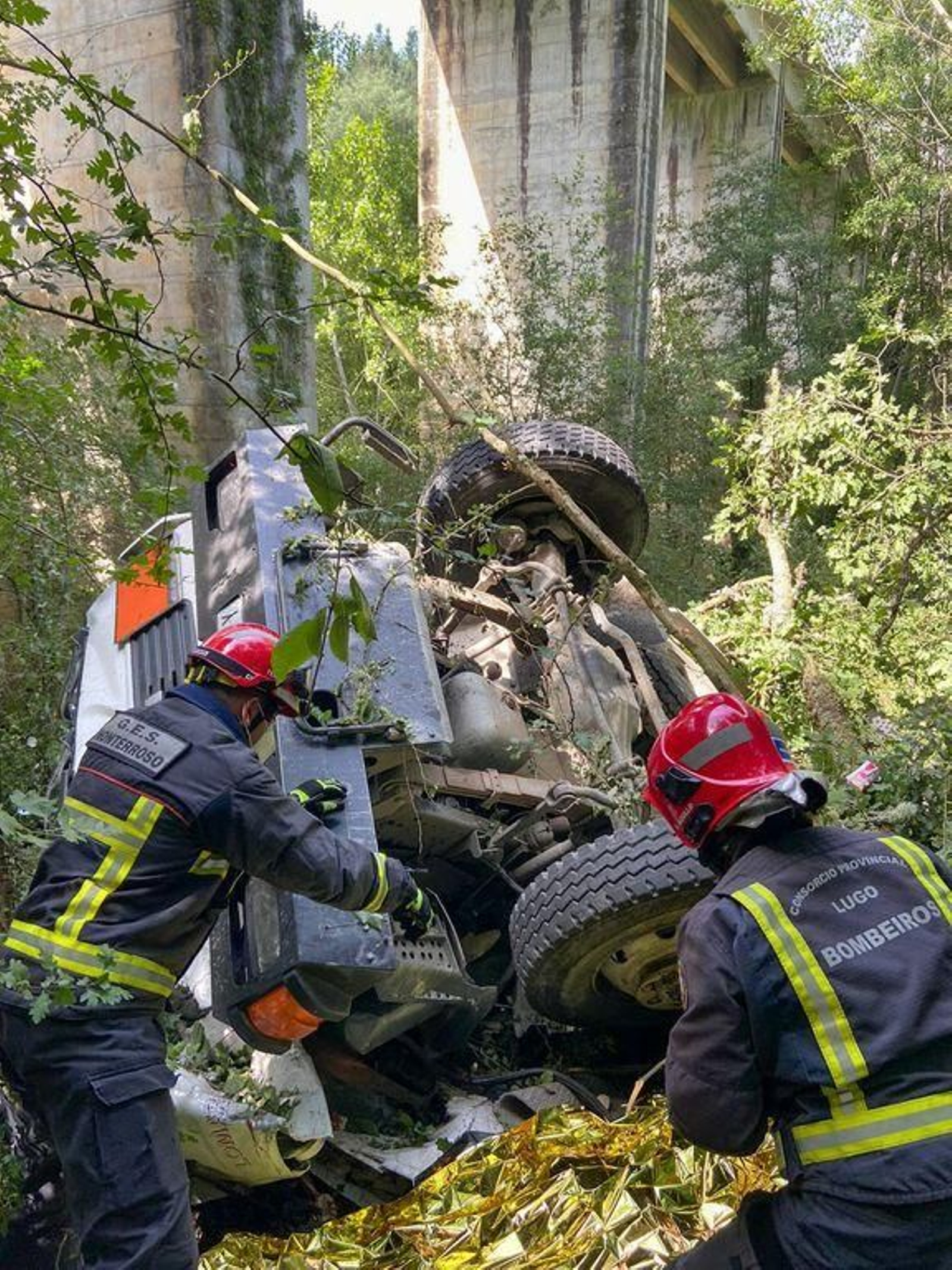 Dos bomberos, ante el camión.