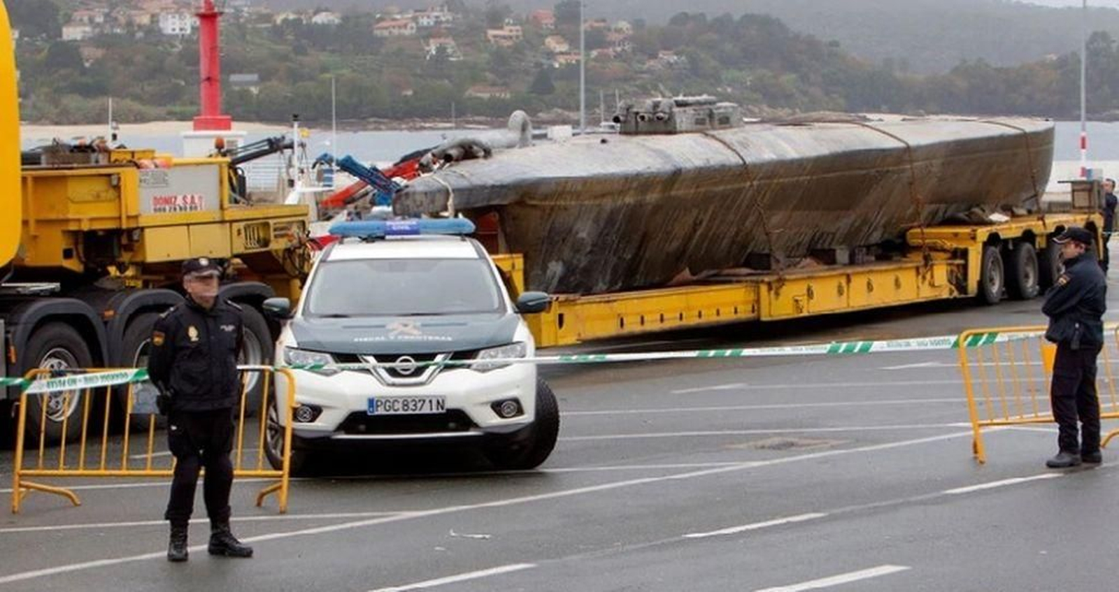 El narcosubmarino, vigilado por las fuerzas de seguridad, en el muelle del puerto de Aldán.