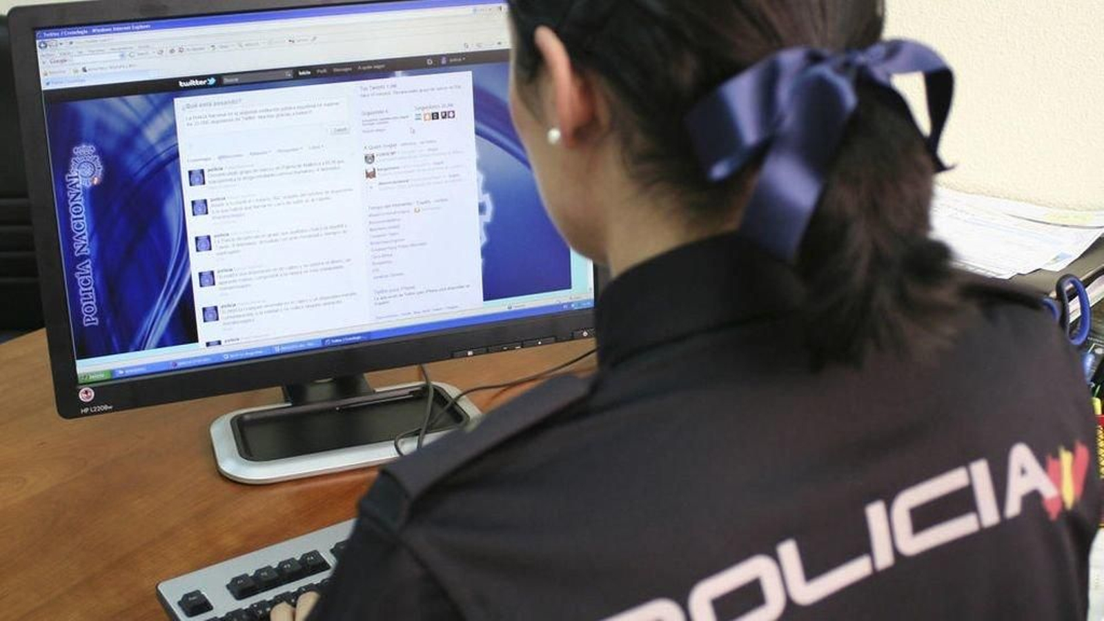 Una agente consulta la cuenta de Twitter de la Policía.
