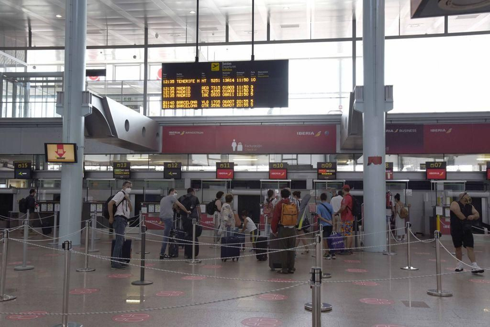 Pasajeros de los vuelos de Binter a Tenerife e Iberia en la operativa diaria con Madrid, ayer en la cola de facturación en el aeropuerto de Vigo.