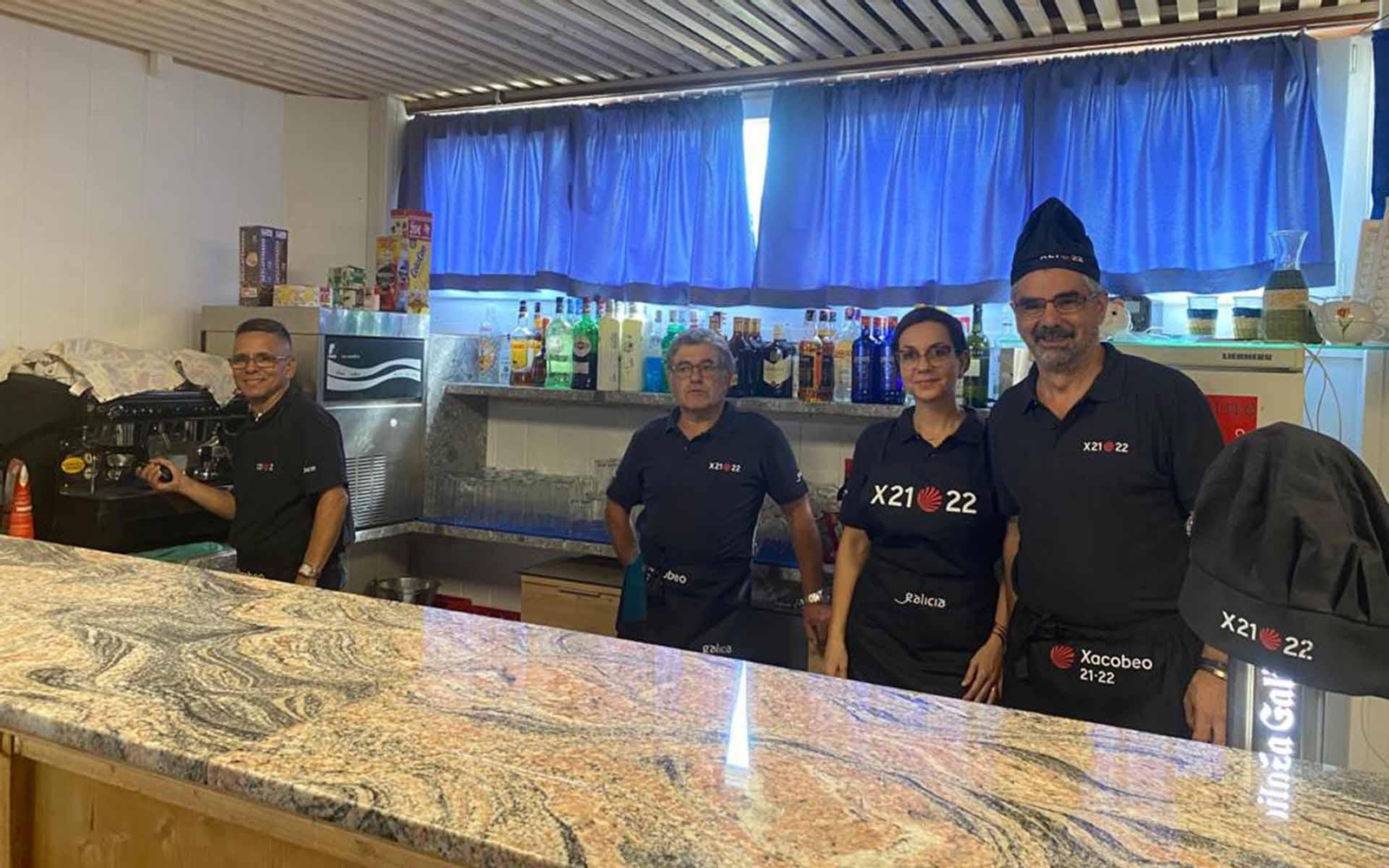 Los trabajadores del Restaurante del Centro Español de Liechtenstein promocionan el Xacobeo 21-22 a través de su material de trabajo