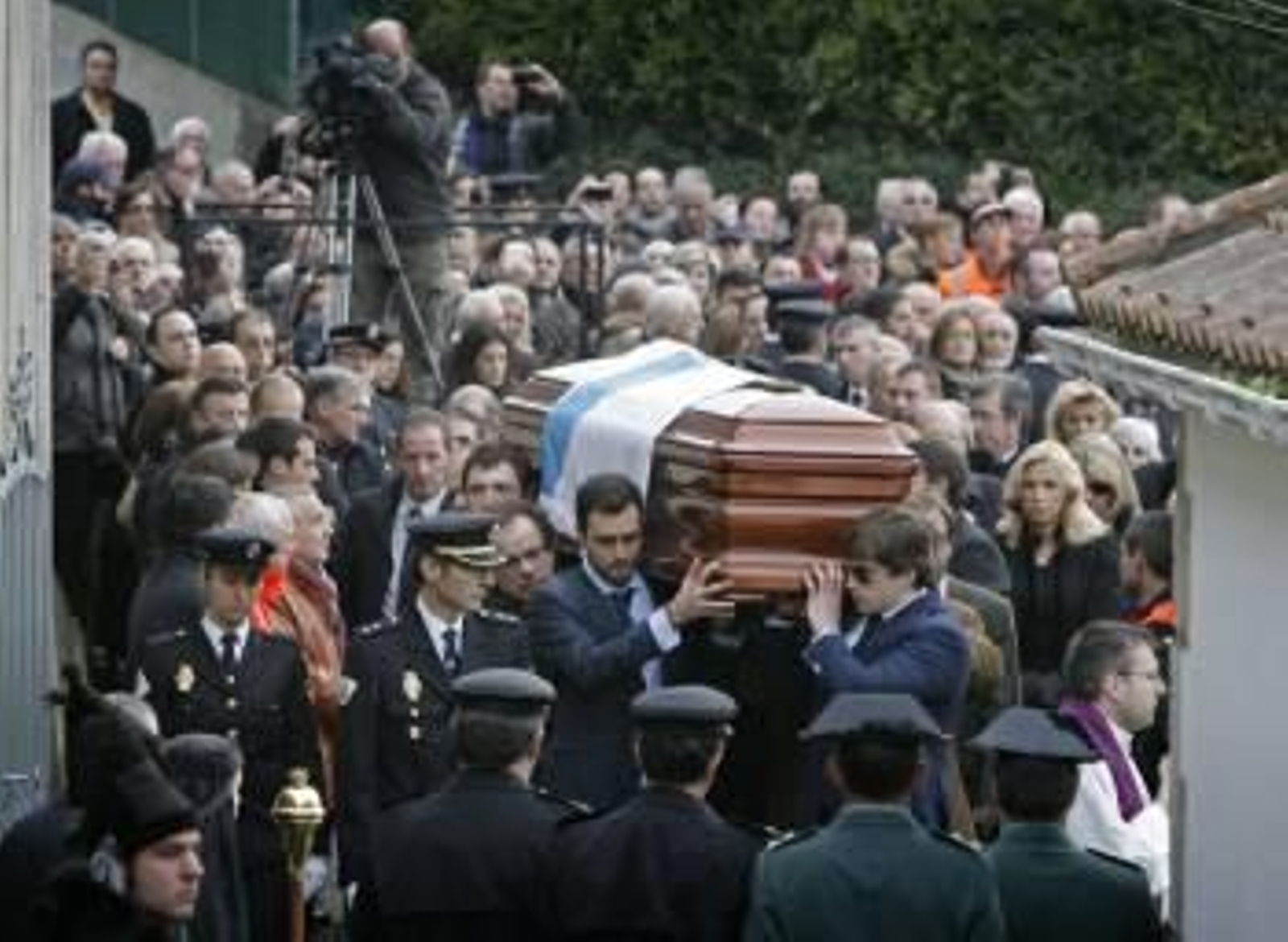 Familiares de Manuel Fraga llevan el féretro cubierto con la bandera de Galicia durante el sepelio celebrado esta tarde en el Parroquia de Perbes (Foto: efe)