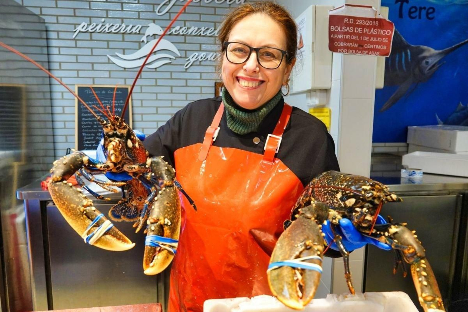 Una pescadera del mercado vigués del Progreso, con dos enormes bogavantes, listos para su venta.