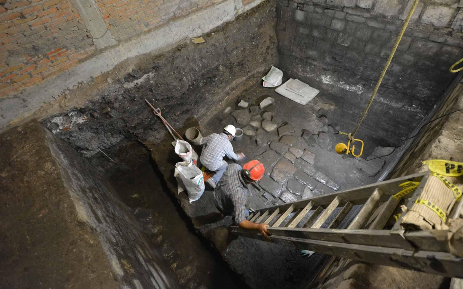 Fotografía cedida lunes por el Instituto Nacional de Antropología e Historia, que muestra a dos Arqueólogos, en los trabajos de unos pisos de lajas de basalto, correspondientes a vestigios de un palacio prehispánico y de la morada del conquistador Cortés en la Ciudad de México.(México). EFE/INHA