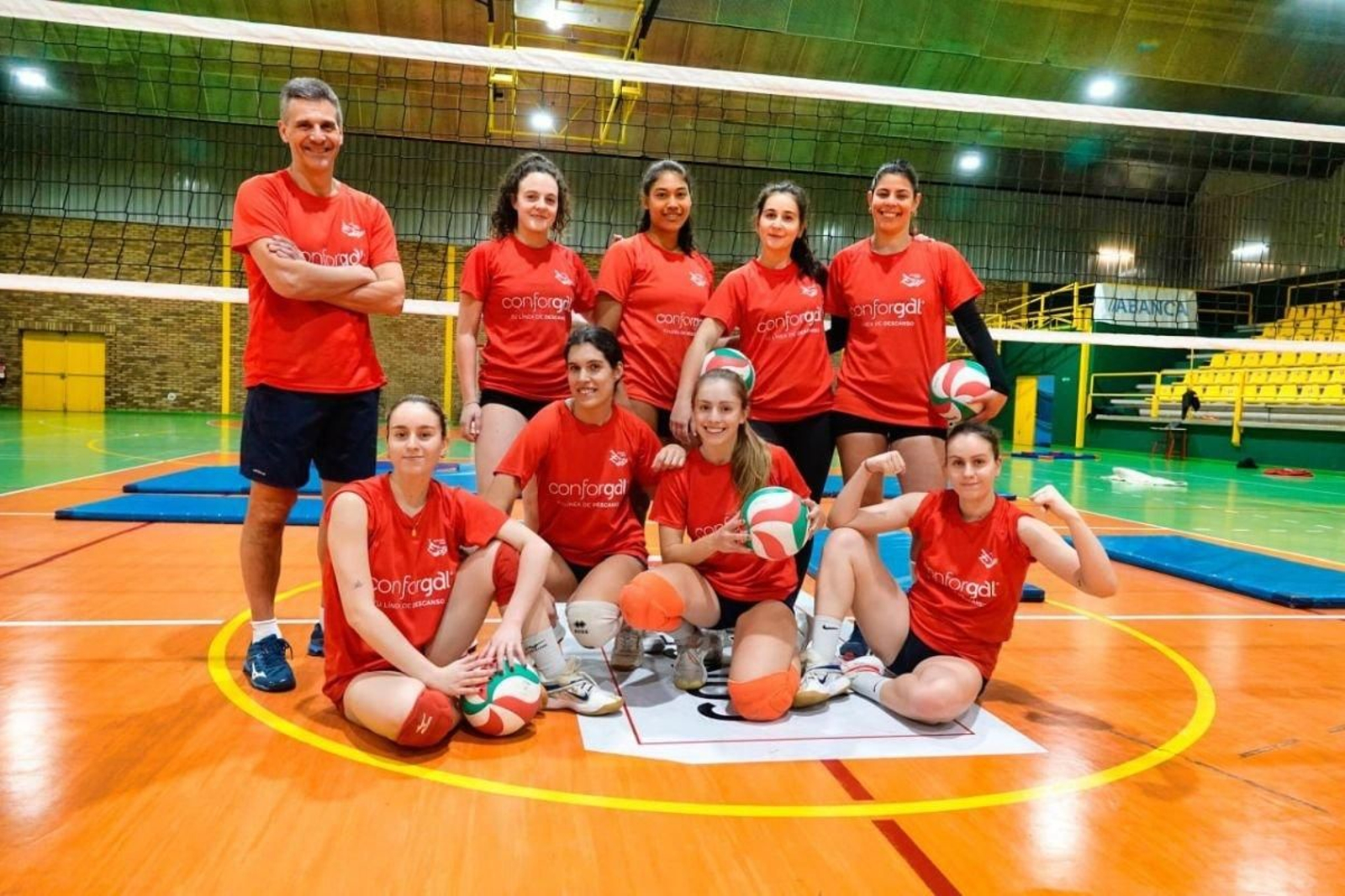 El técnico Alberto Bao y sus jugadoras posan durante el entrenamiento que el equipo realizó ayer en el pabellón de Teis, hogar del Xuvenil.