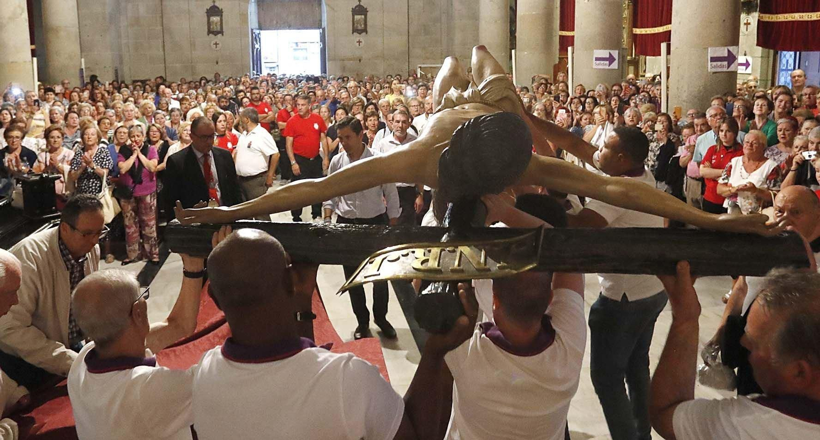 El momento en que los cofrades alzan al Cristo del altar mayor, ayudados por poleas y cuerdas.