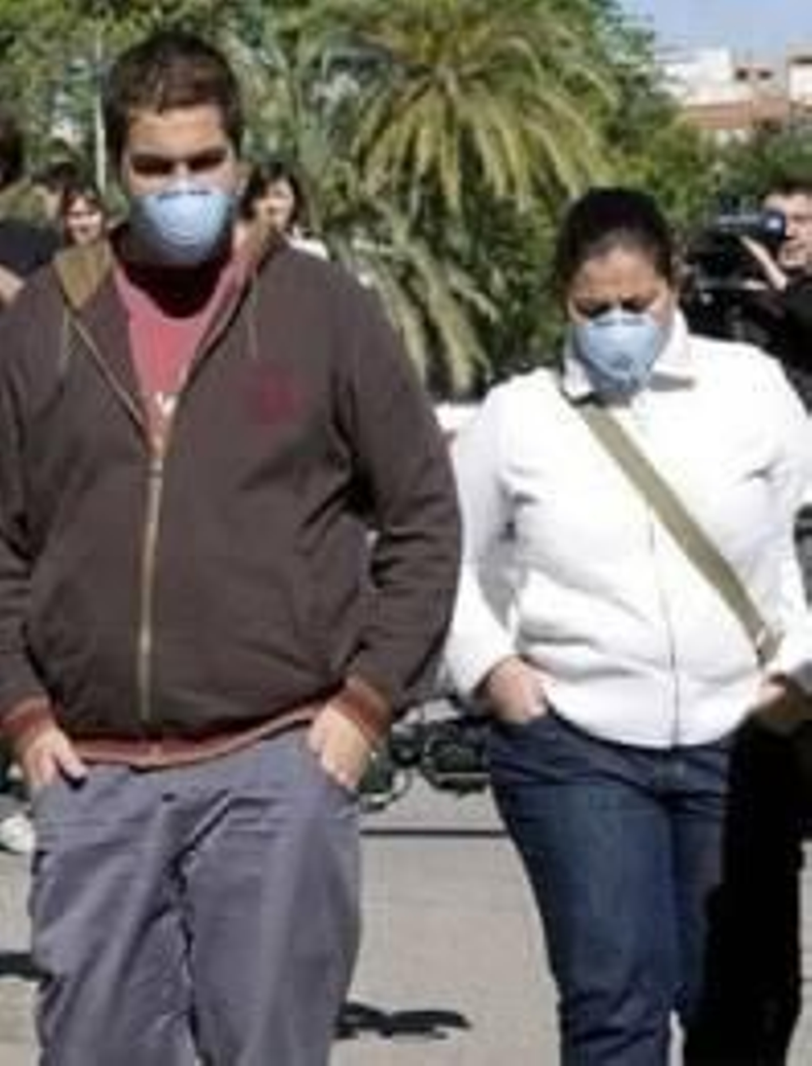 Dos personas usan mascarillas para evitar el contagio.