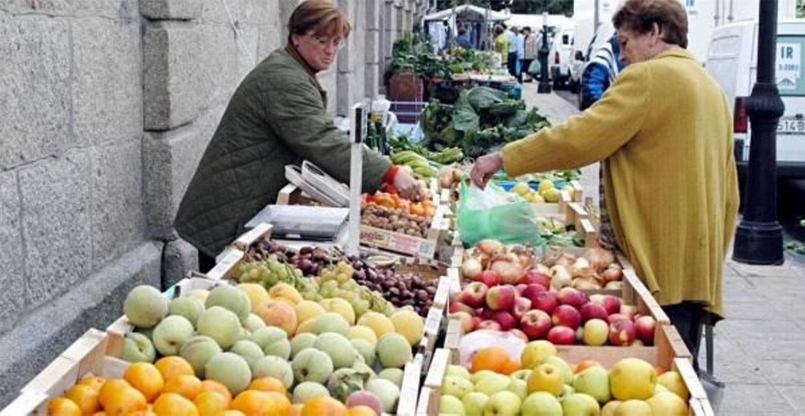 Una mujer compra fruta en un mercadillo de Cangas. (Foto: Archivo)