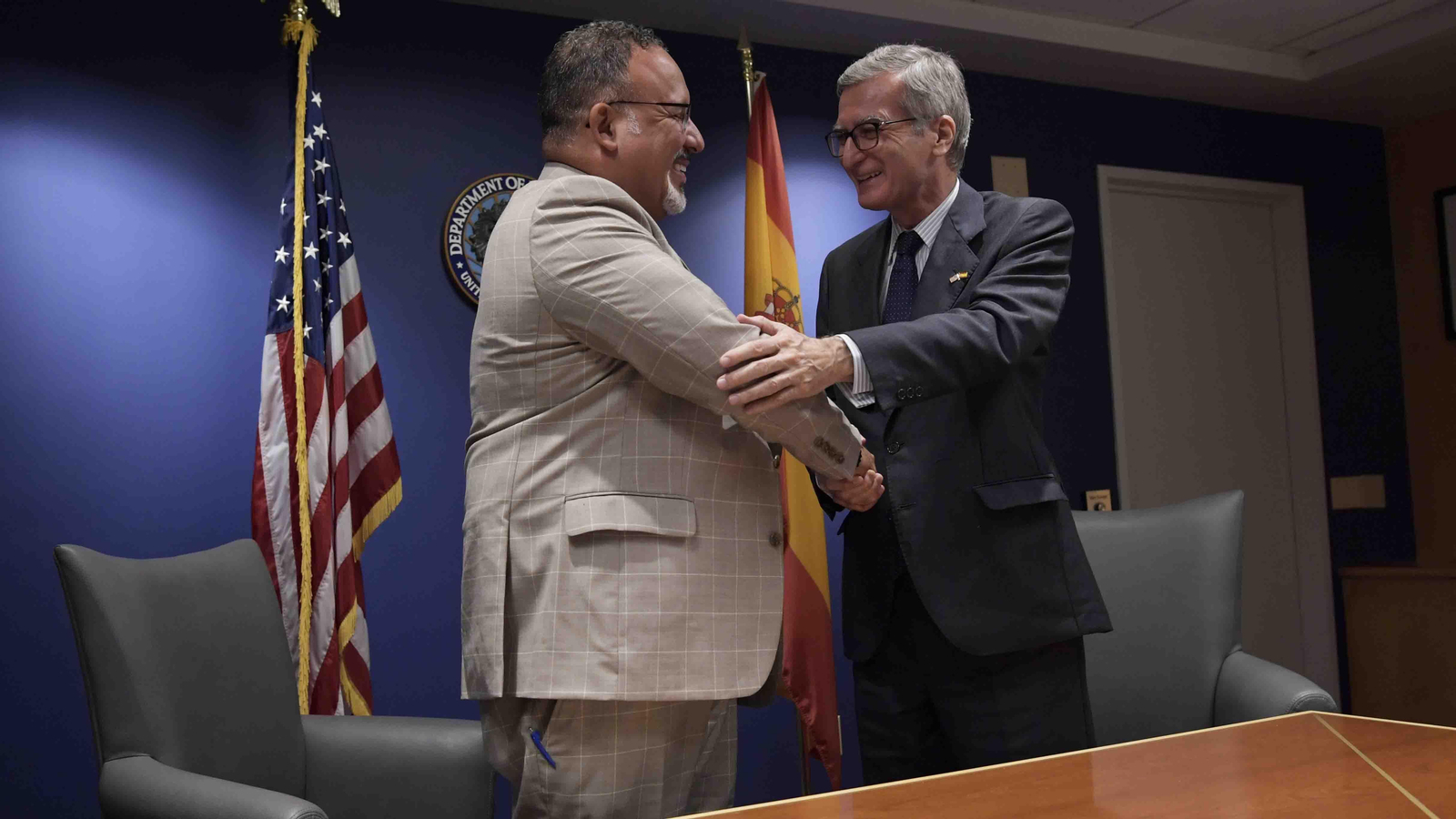 El secretario de Educación de EE.UU., Miguel Cardona (i), saluda al embajador de España en Washington, Santiago Cabanas (d) después de la firma del nuevo Memorándum de Entendimiento entre ambos departamentos para promover una educación bilingüe. Foto EFE