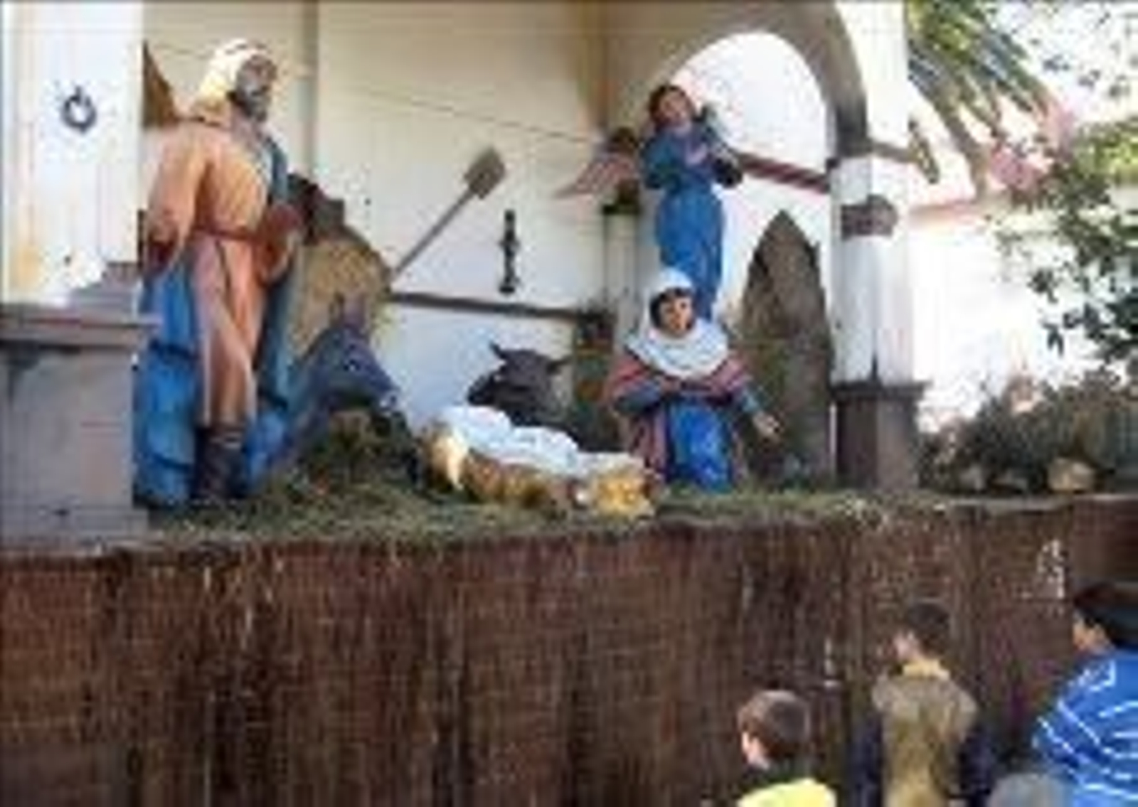 Los niños observan el belén, pero la cuna está vacía.