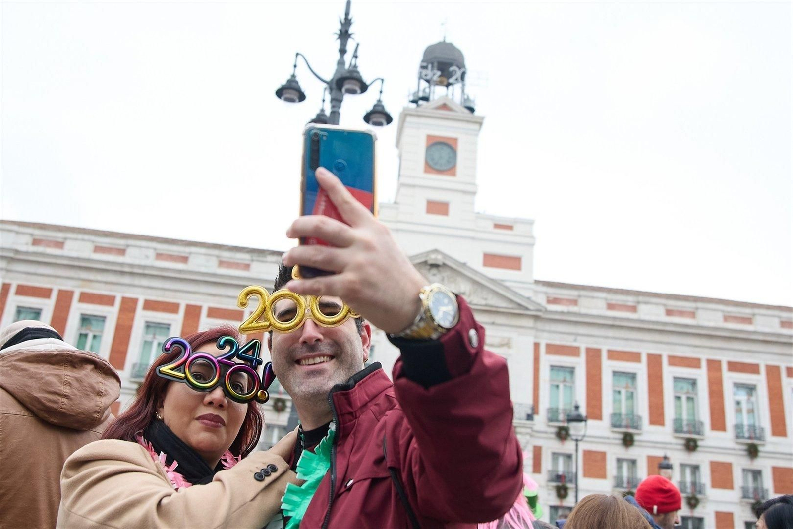 Dos personas en la Puerta del Sol de Madrid celebran la llegada del 2024. // Europa Press
