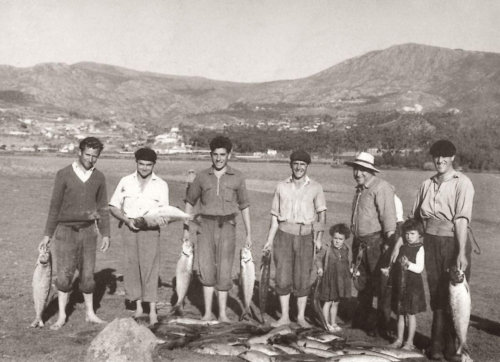 Fotografía del siglo pasado protagonizada por pescadores locales con el Miño de fondo.