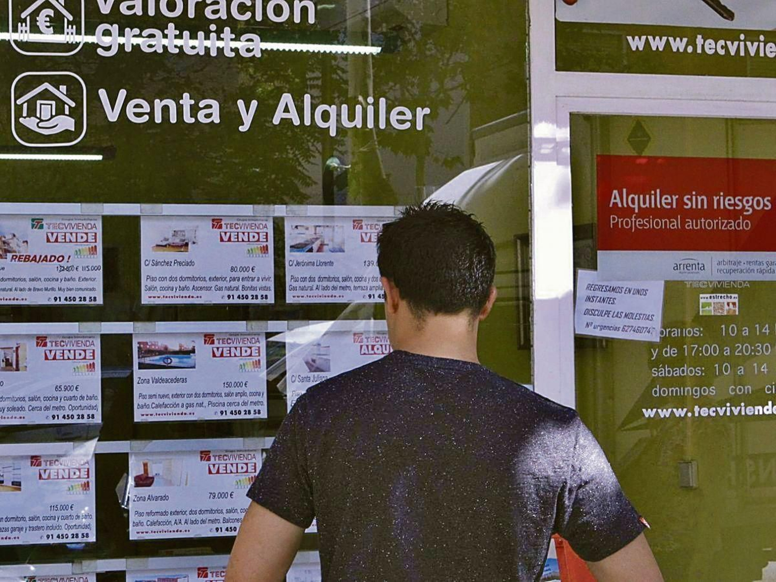 Un joven revisa ofertas de alquiler de una inmobiliaria.