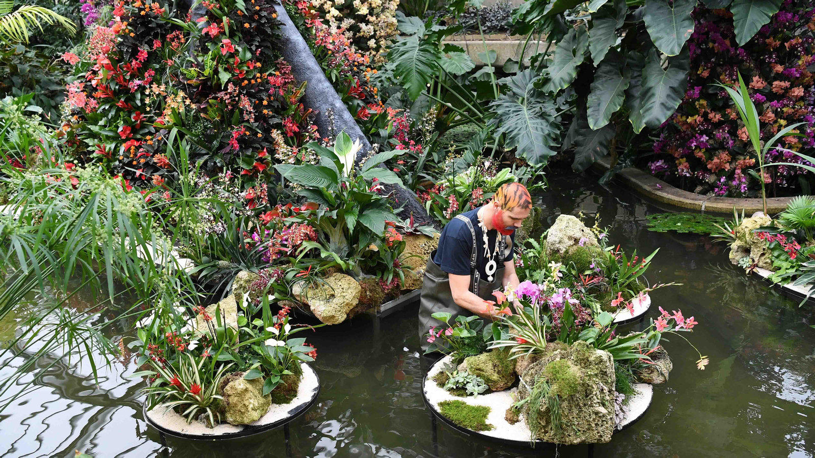 Un empleado de Kew Gardens posa para los fotógrafos frente a las plantas. EFE/EPA/FACUNDO ARRIZABALAGA
