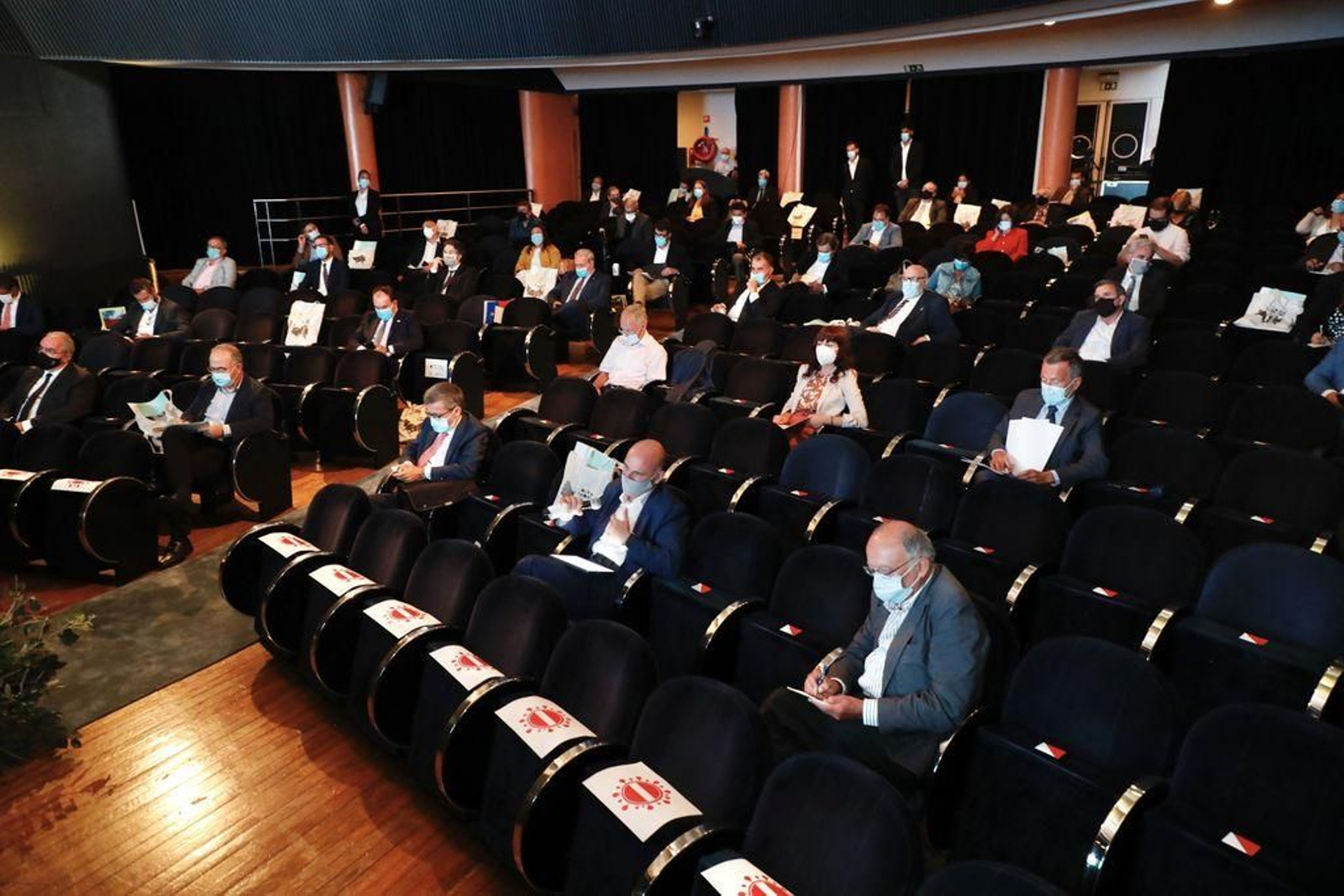 Los asistentes, con distancia obligada para sentarse.