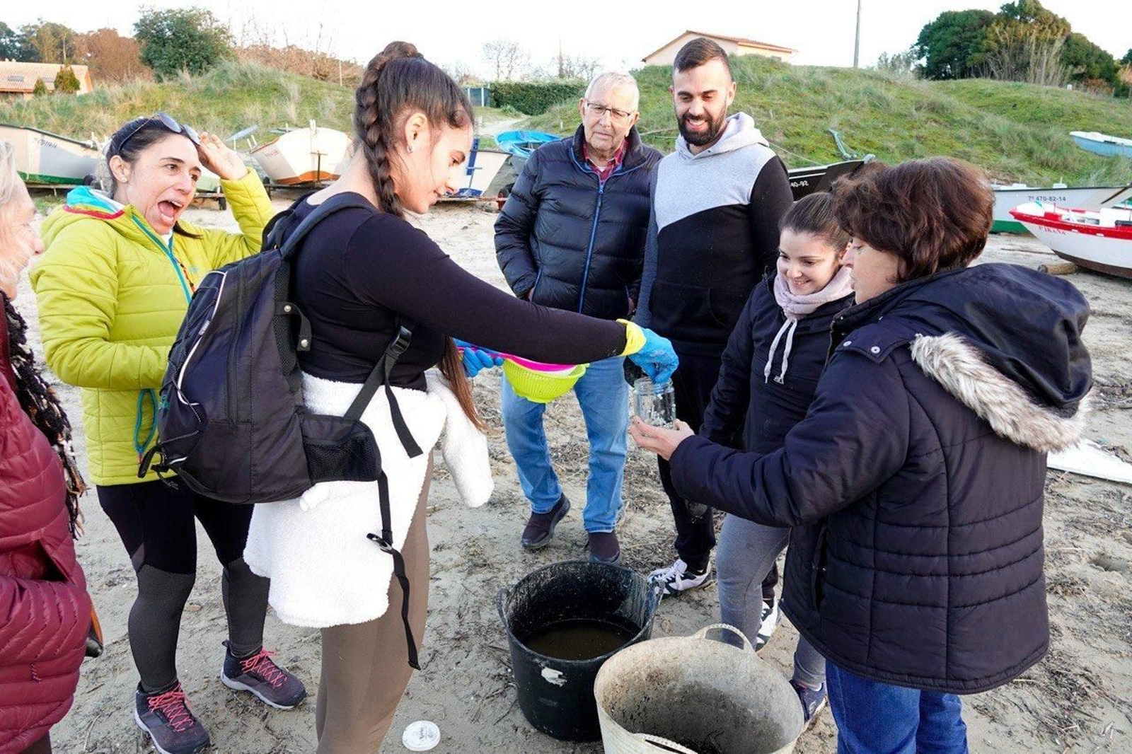 Voluntarios recogen pellets de plástico.