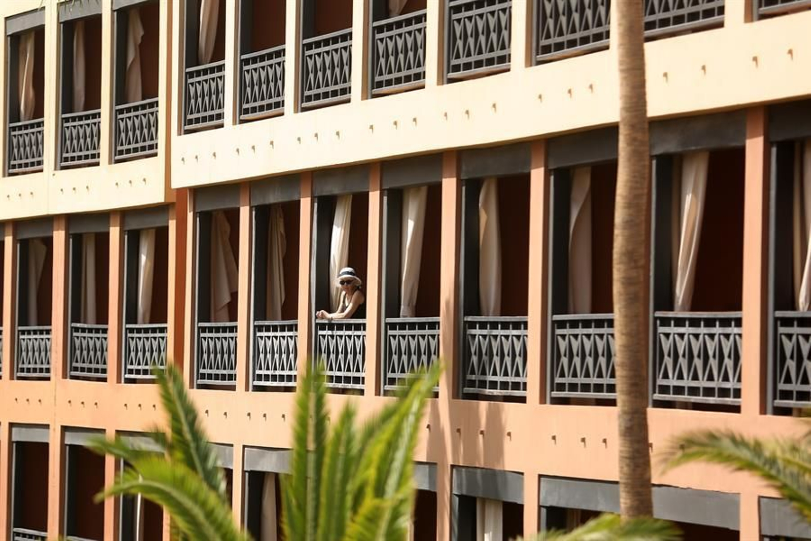 Una turista se asoma al balcón de su habitación, en el hotel situado del sur de Tenerife