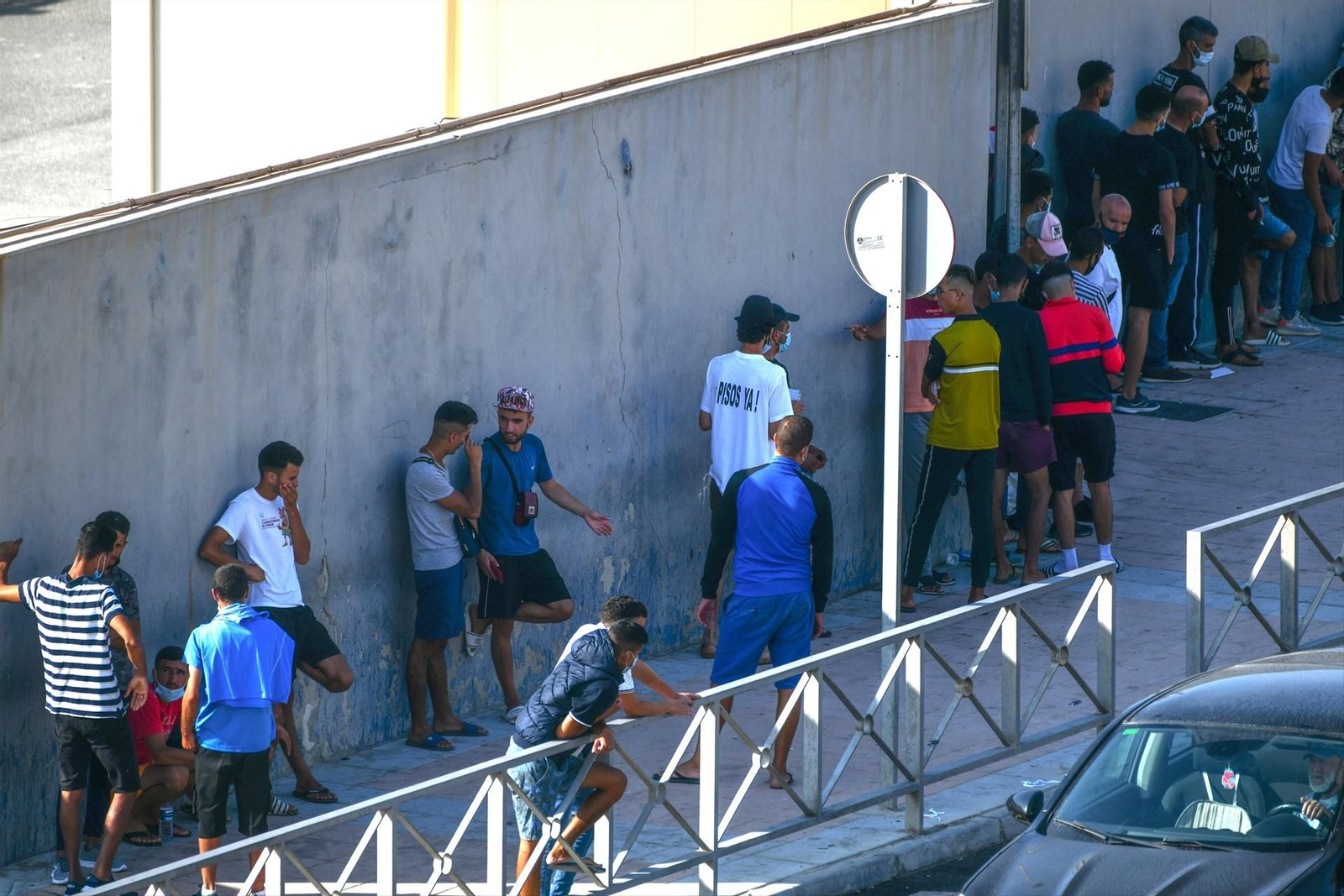 En la imagen, cientos de personas, la mayoría marroquíes, guardan cola en la oficina para tramitar los asilos situada en la frontera del Tarajal, que separa Ceuta de Marruecos.