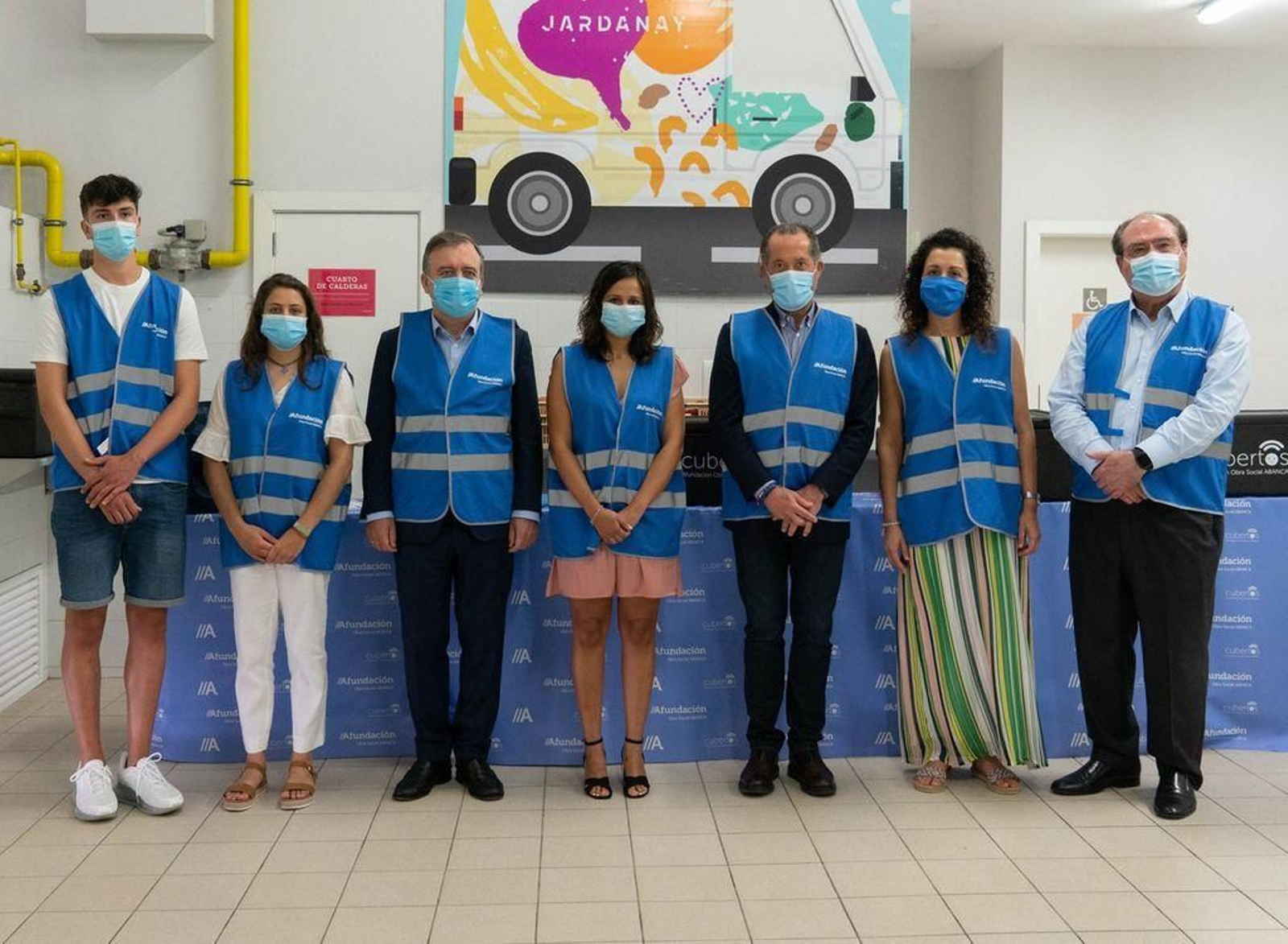 Botas, Juan Carlos Escotet y Miguel Ángel Escotet posan con voluntarios.