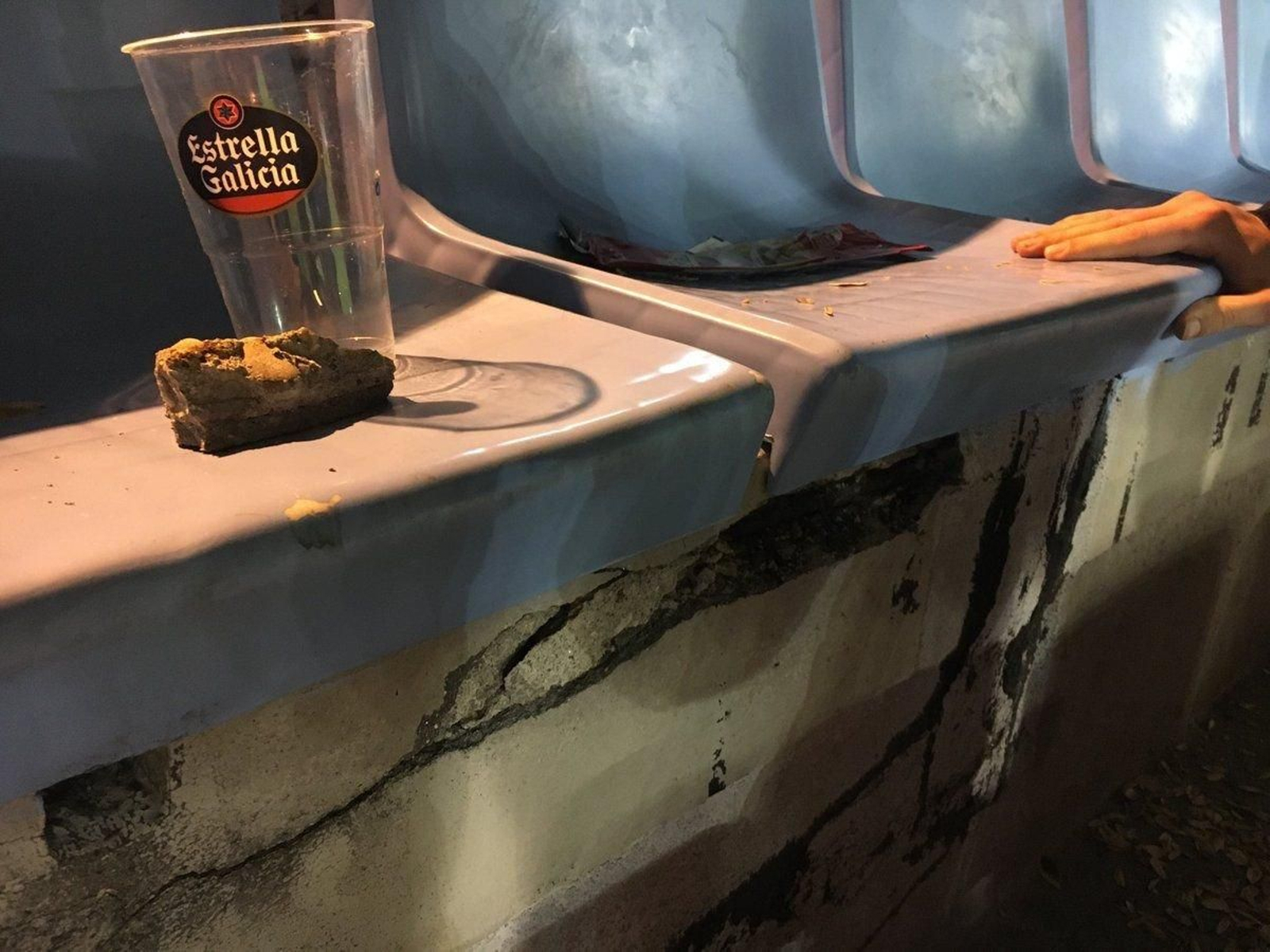 Imagen del deterioro de la grada de Marcador con un cascote.