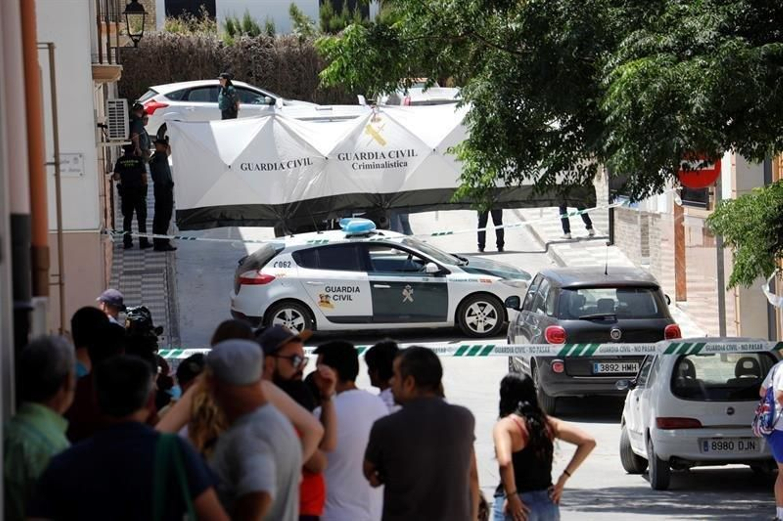 Agentes de la Guardia Civil despliegan una lona para tapar el traslado del cuerpo sin vida de la mujer de 42 años asesinada presuntamente por su marido en su vivienda