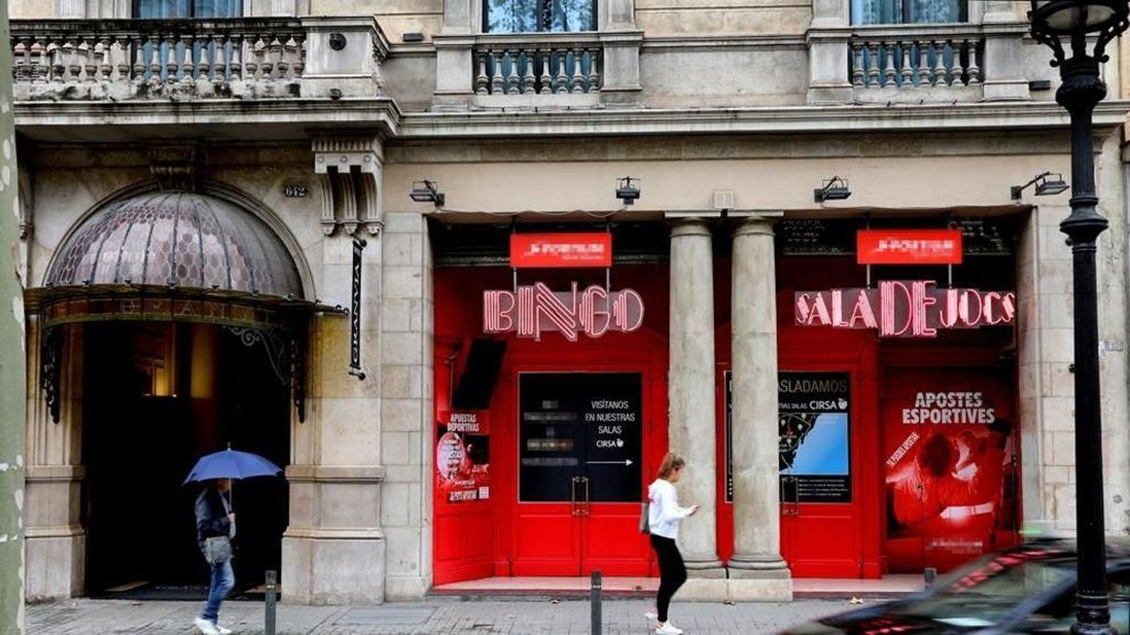 Dos personas caminan por delante de una sala de juegos en Barcelona.