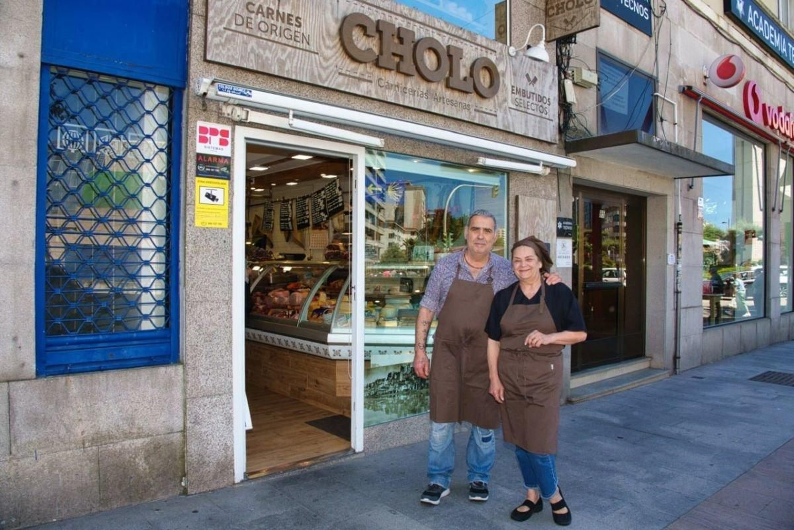 José Manuel y Pili. ante su carnicería, “Cholo”, al final de Lopez Mora, ayer.
