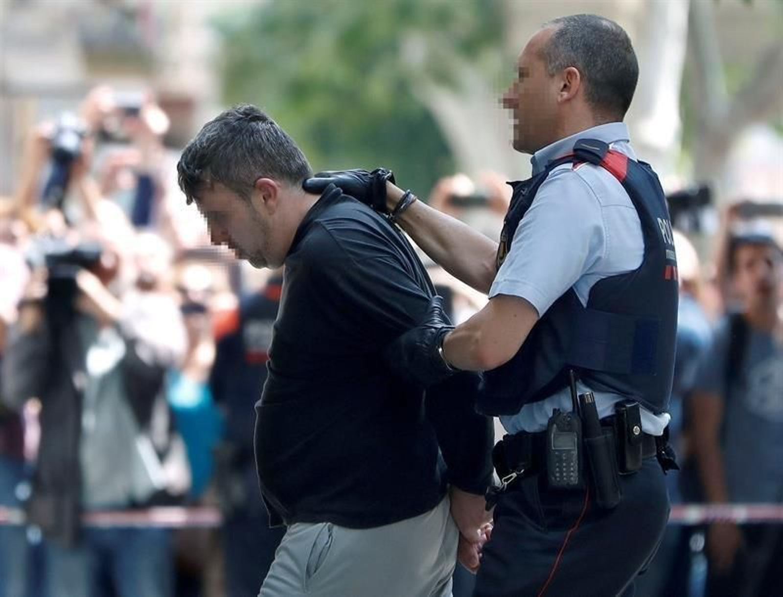 El detenido por el asesinato de la niña escoltado por los Mossos antes del registro de la vivienda.
