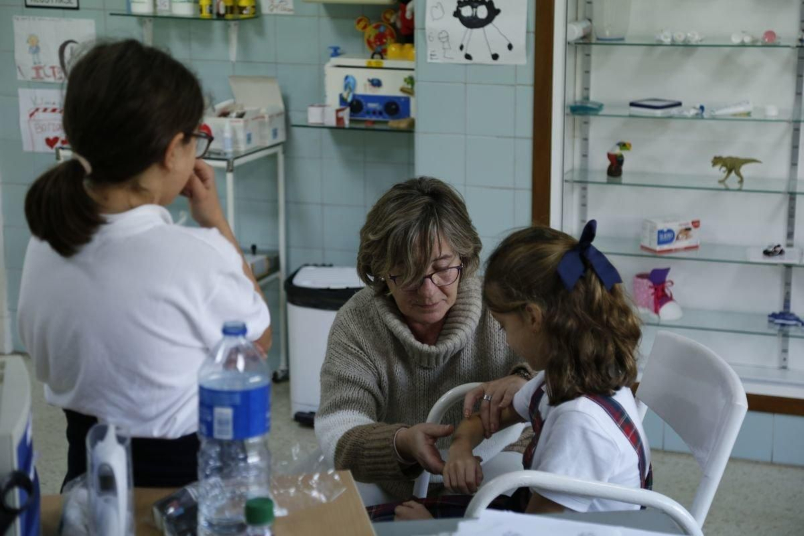 Victoria Vázquez, atendiendo a dos alumnas en la Enfermería.