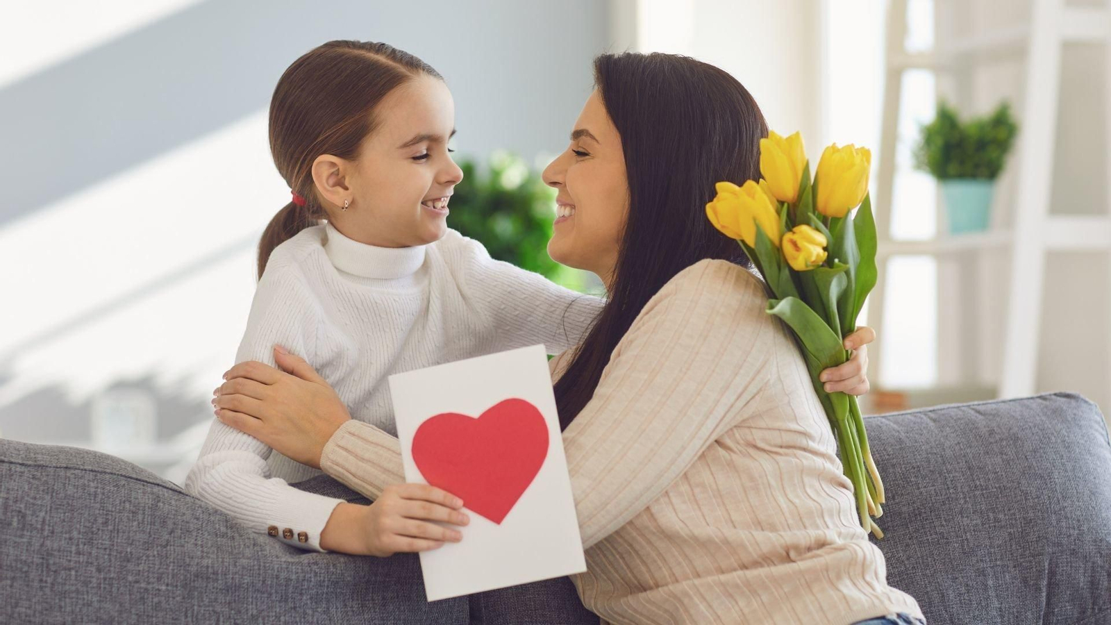 Una niña le entrega a su madre varios detalles por el Día de la madre. // Canva