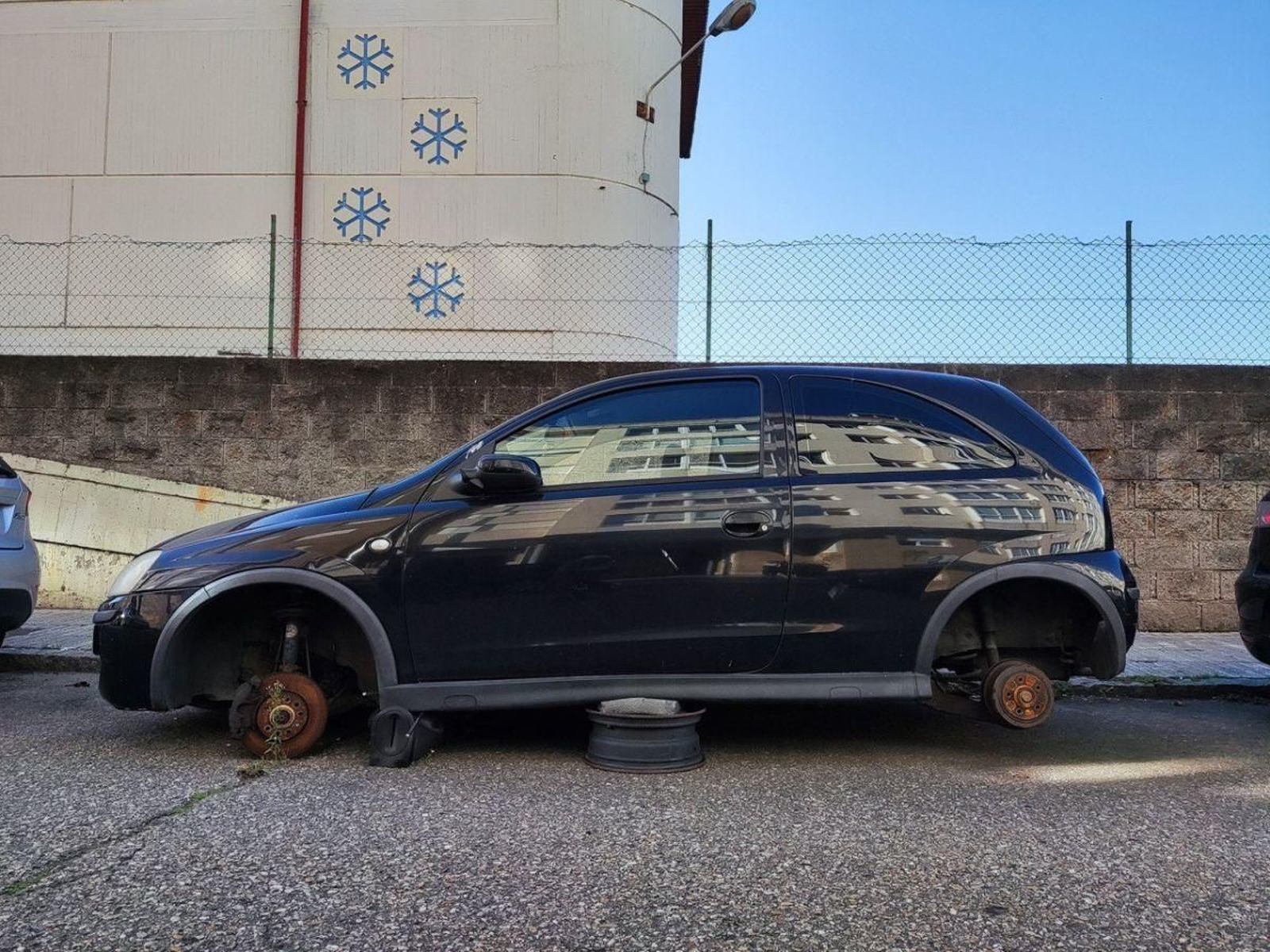 Uno de los vehículos abandonados en la calle Marqués de Valterra, sin ruedas.
