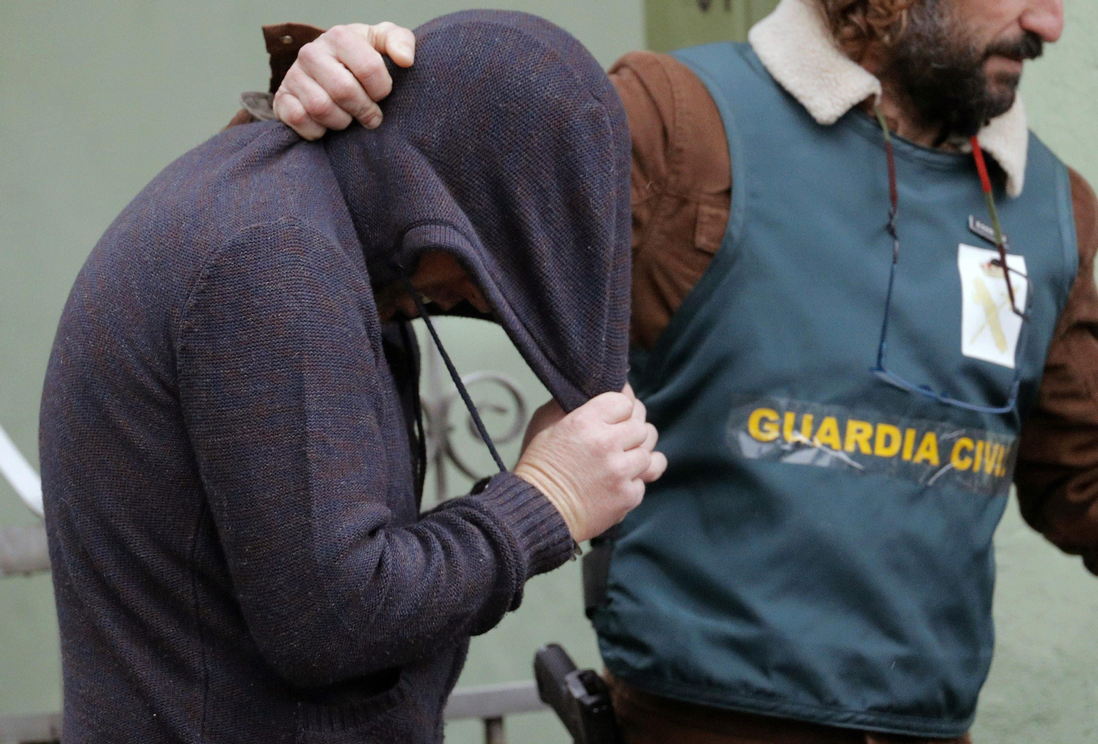 Un agente traslada a Abuín Gey, con capucha, el día 31 de diciembre, tras el registro de su domicilio.