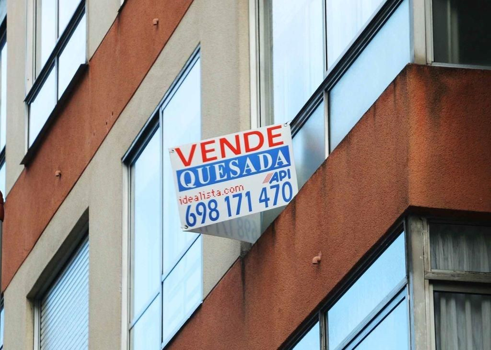 Arriba variación del precio en Vigo, abajo un cartel de piso en venta.