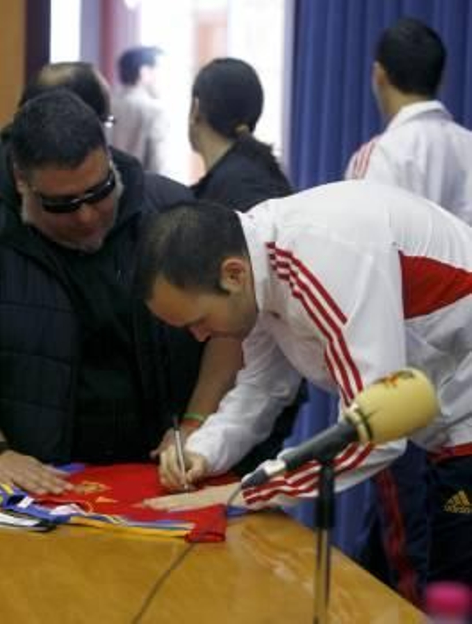 Iniesta firma un autógrafo antes de partir hacia Kaunas.? (Foto: víctor lerena)