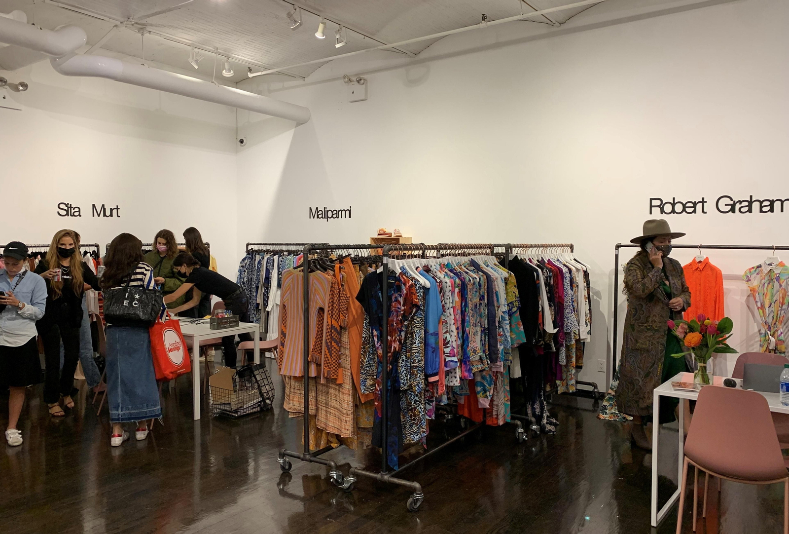 Varias personas miran los diferentes diseños de las marcas participantes en la feria FashionLab Market en Nueva York. EFE/Nora Quintanilla