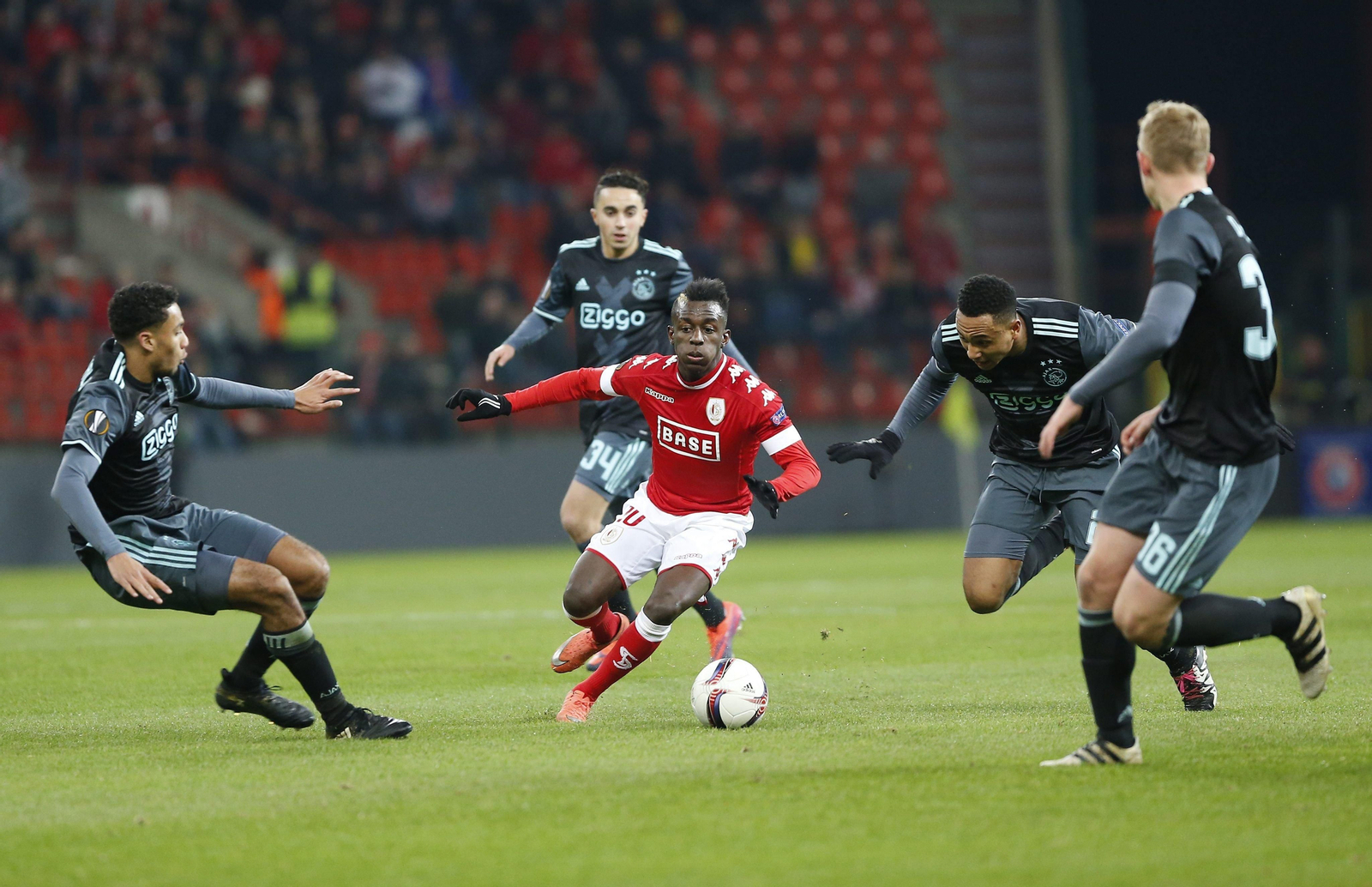 El futbolista del Standard de Lieja Dompé trata de eludir el marcaje de varios jugadores del Ajax.