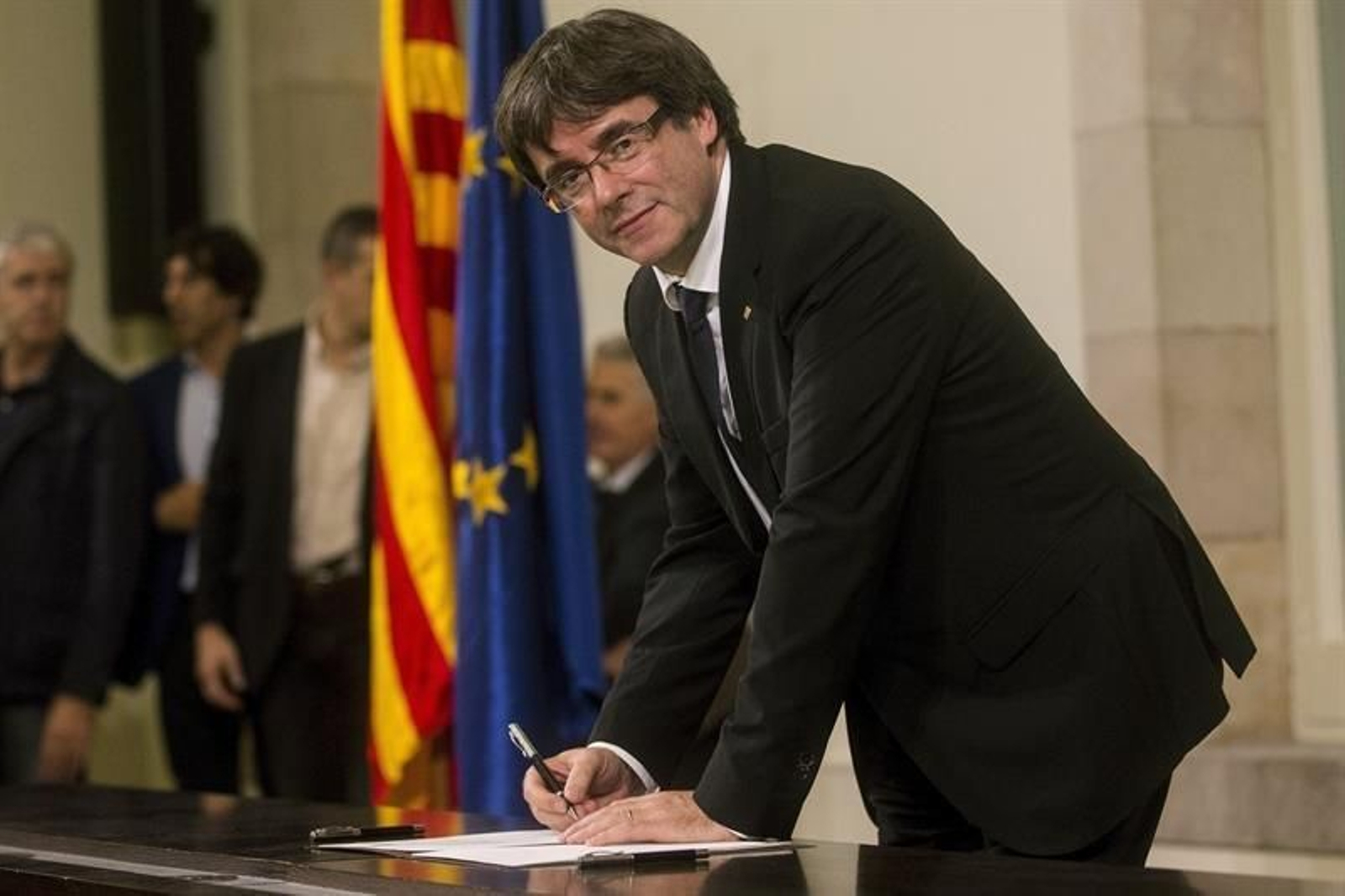 El presidente de la Generalitat, Carles Puigdemont, firma el documento
