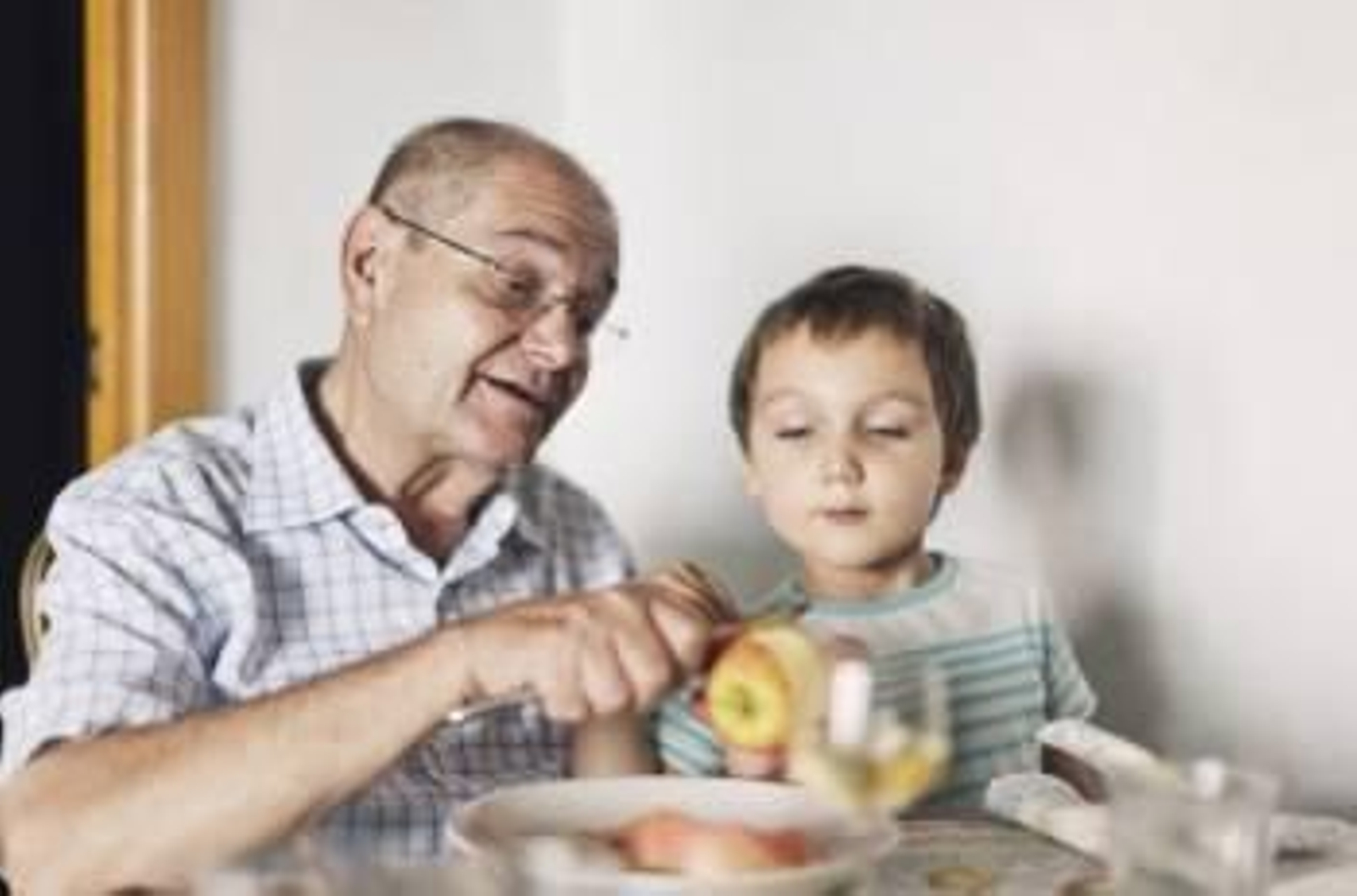Un abuelo enseña a pelar una manzana a su nieto durante la hora de la comida. (Foto: ARCHIVO)